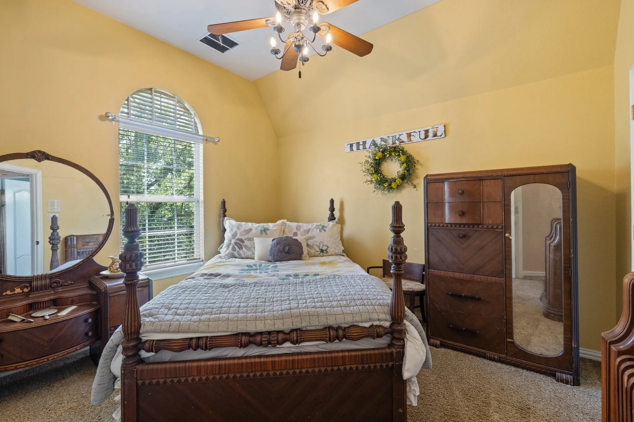Carpeted bedroom with a ceiling fan and arched window