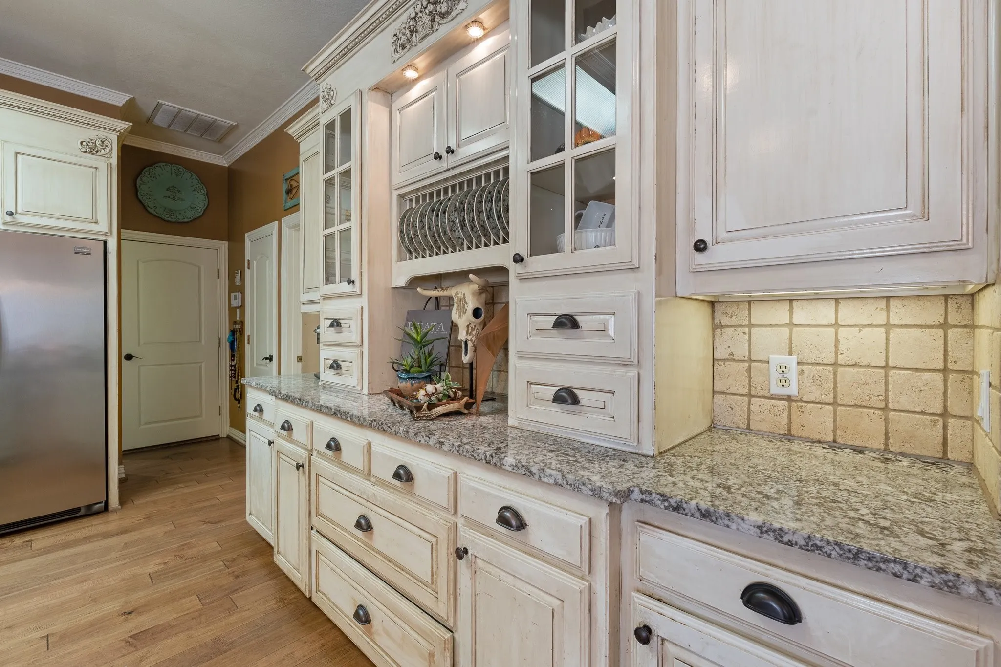 Kitchen with expansive custom cabinetry wall with lighting