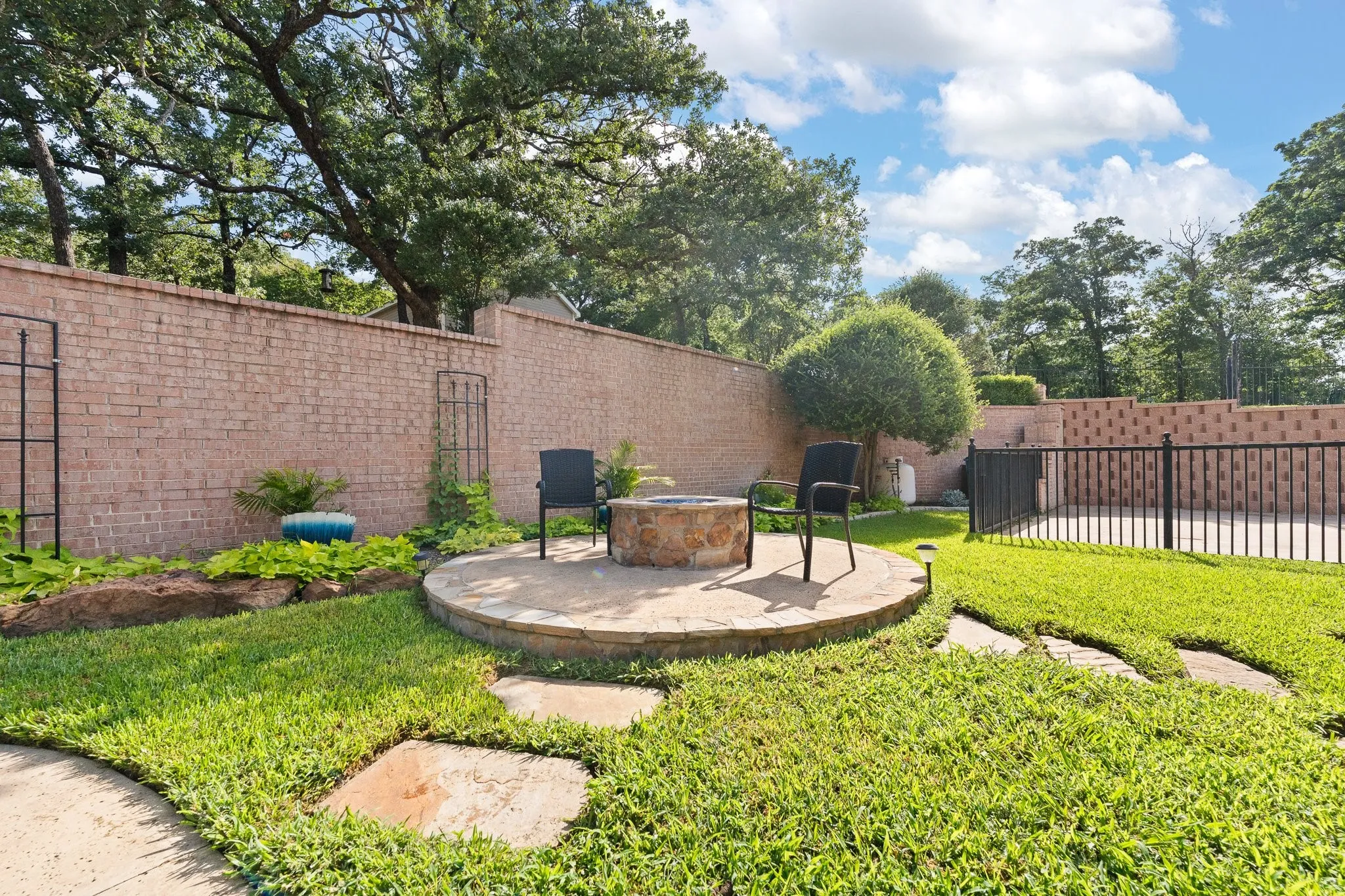 Outdoor living space featuring a stone fire pit on a circular paved patio