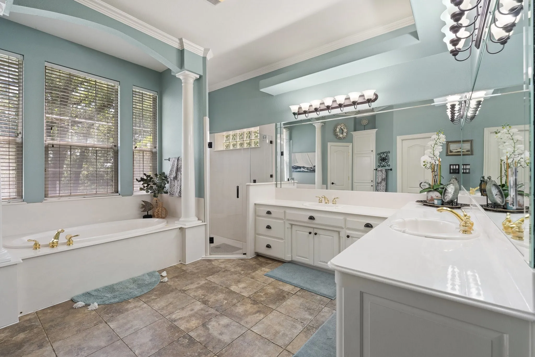 Spacious bathroom featuring a built-in soaking tub, a separate shower enclosure, and a double vanity with white cabinetry and countertops