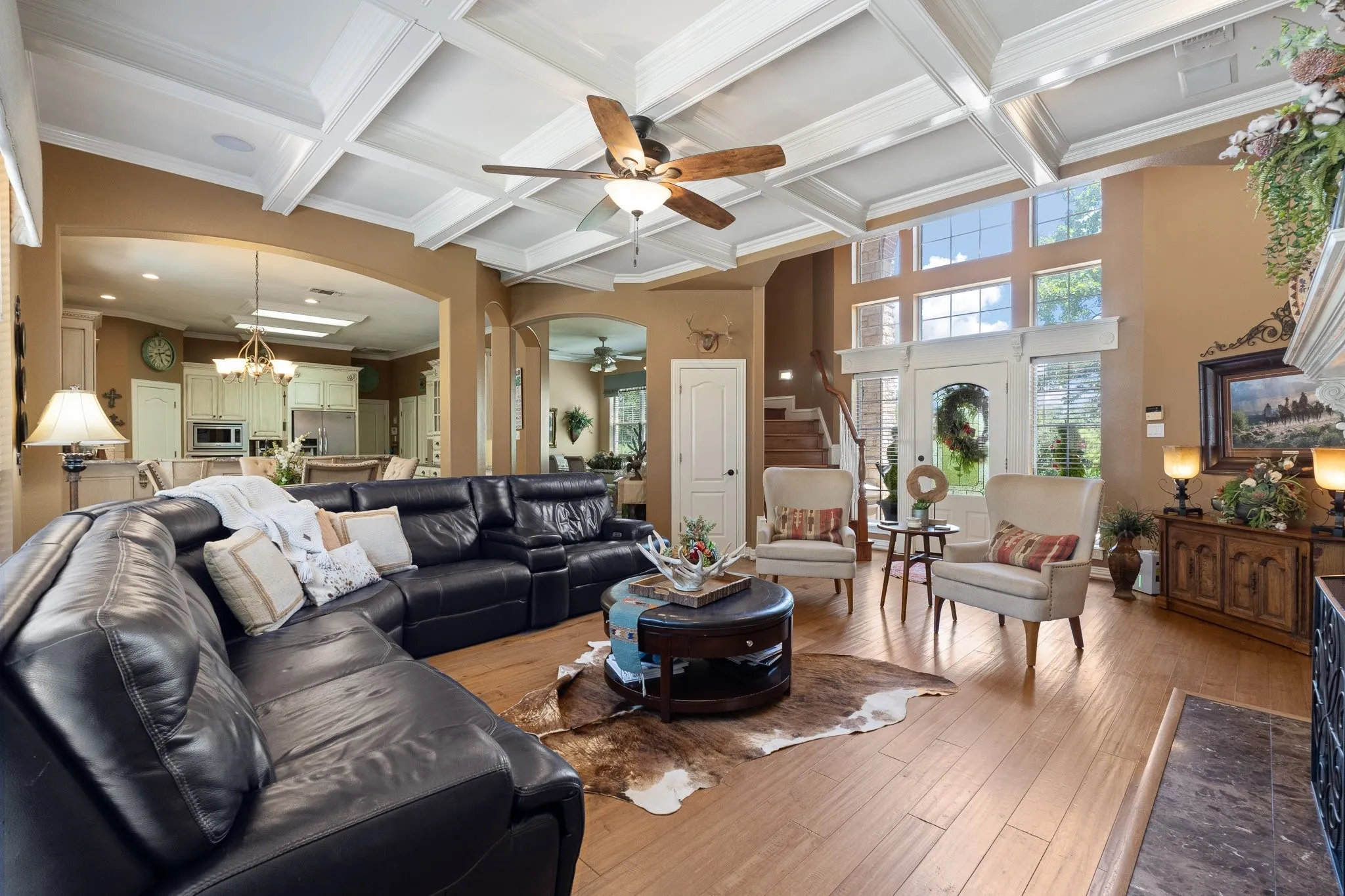 Living room featuring oversized fireplace, mantle and architectural wood beamed ceilings