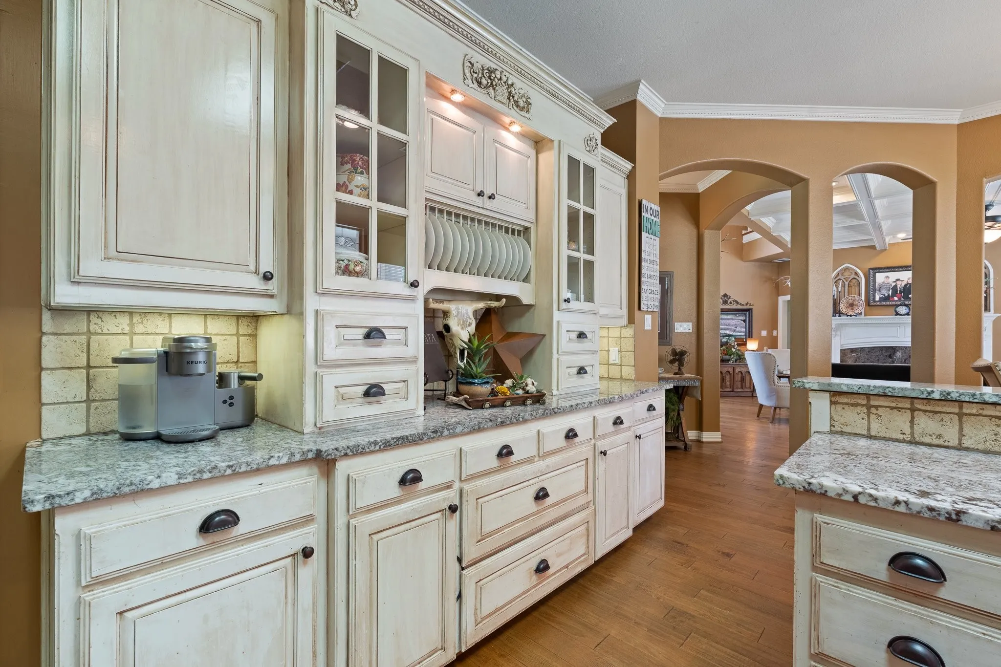 Custom cabinetry with glass-front uppers and plate rack storage
