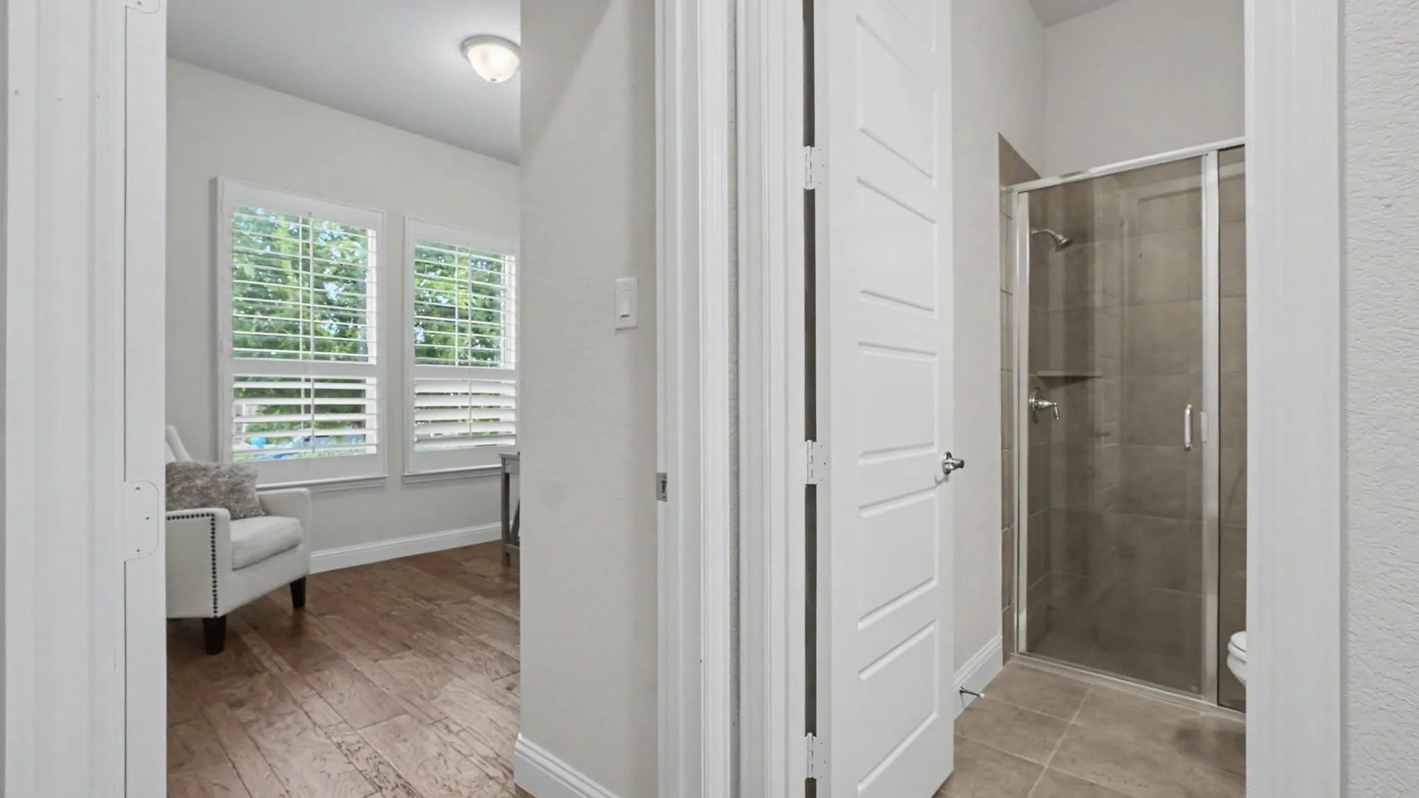 Hallway featuring hardwood floors, showing the entry to front bedroom/office.