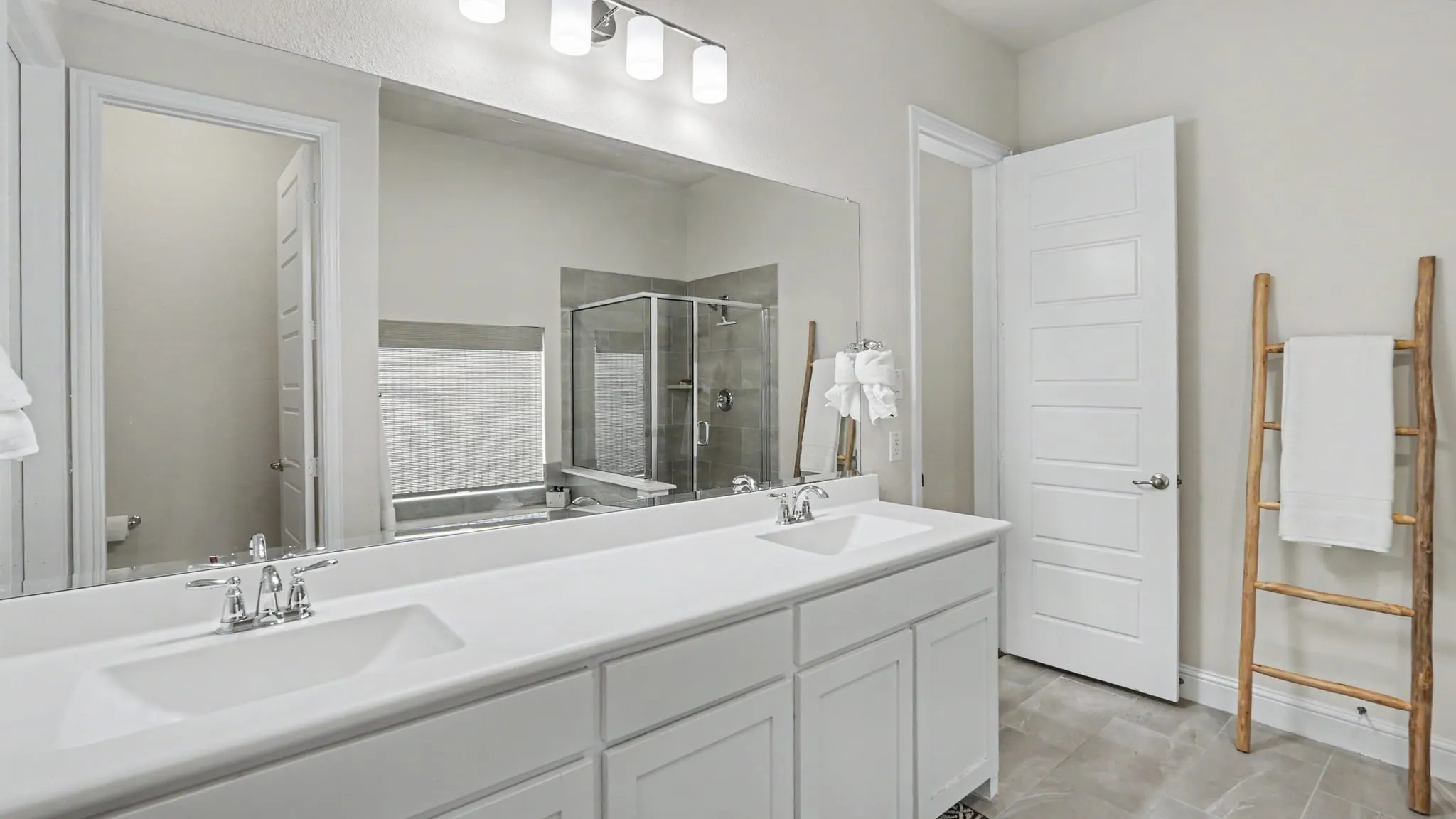 Double vanity featuring undermount sinks, chrome faucets, and white cabinetry.