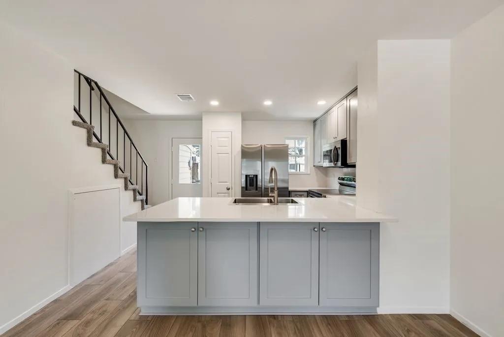 Kitchen island with light blue cabinetry and a white countertop