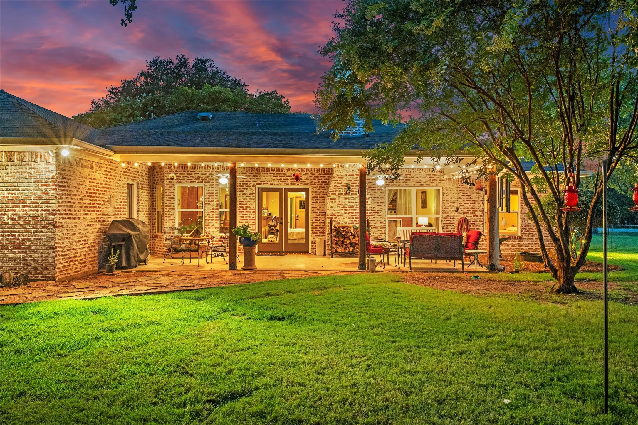 Covered patio with  multiple outdoor seating areas, and a spacious lawn