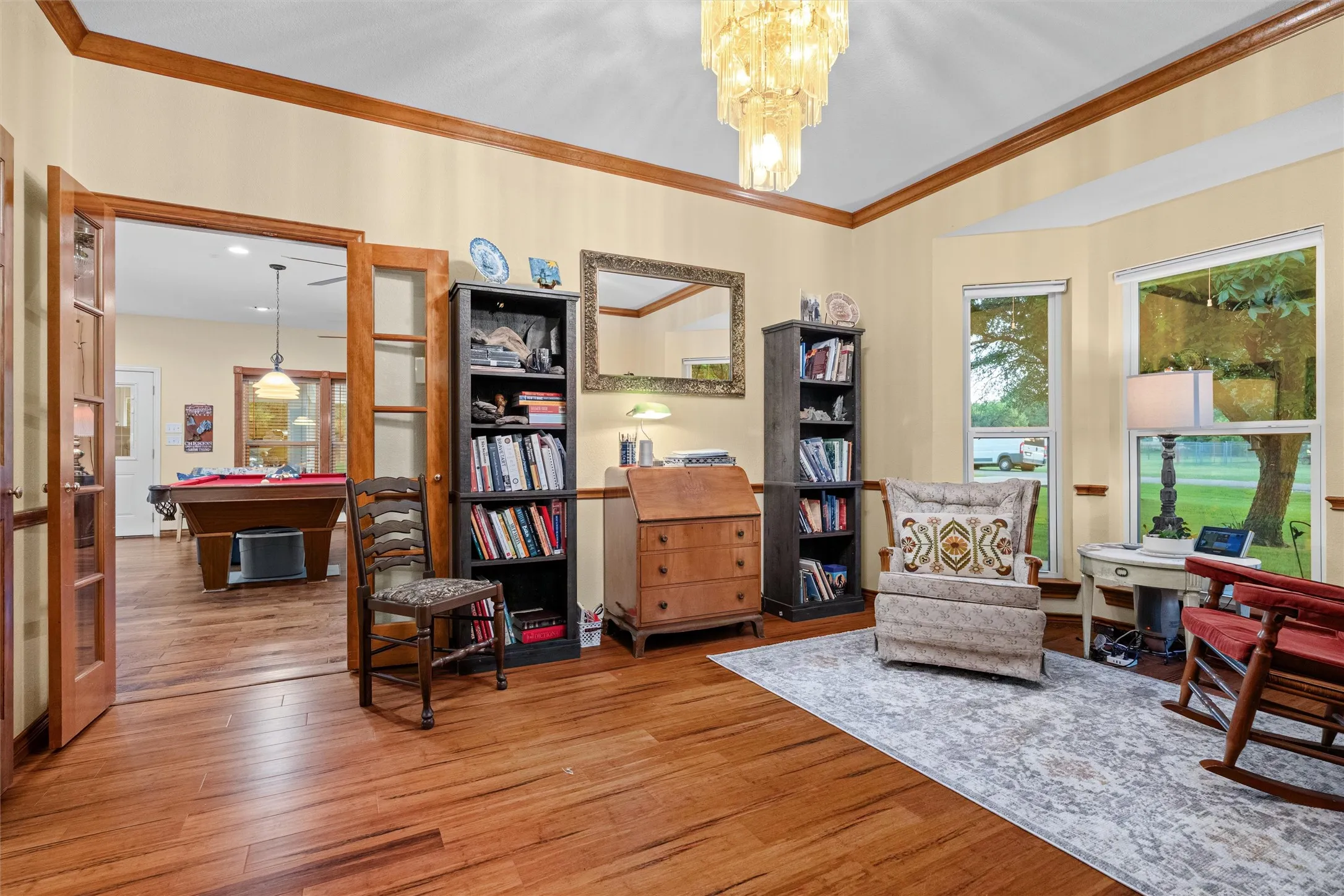 Hardwood flooring throughout, bay windows, and a glass-paneled double door entry
