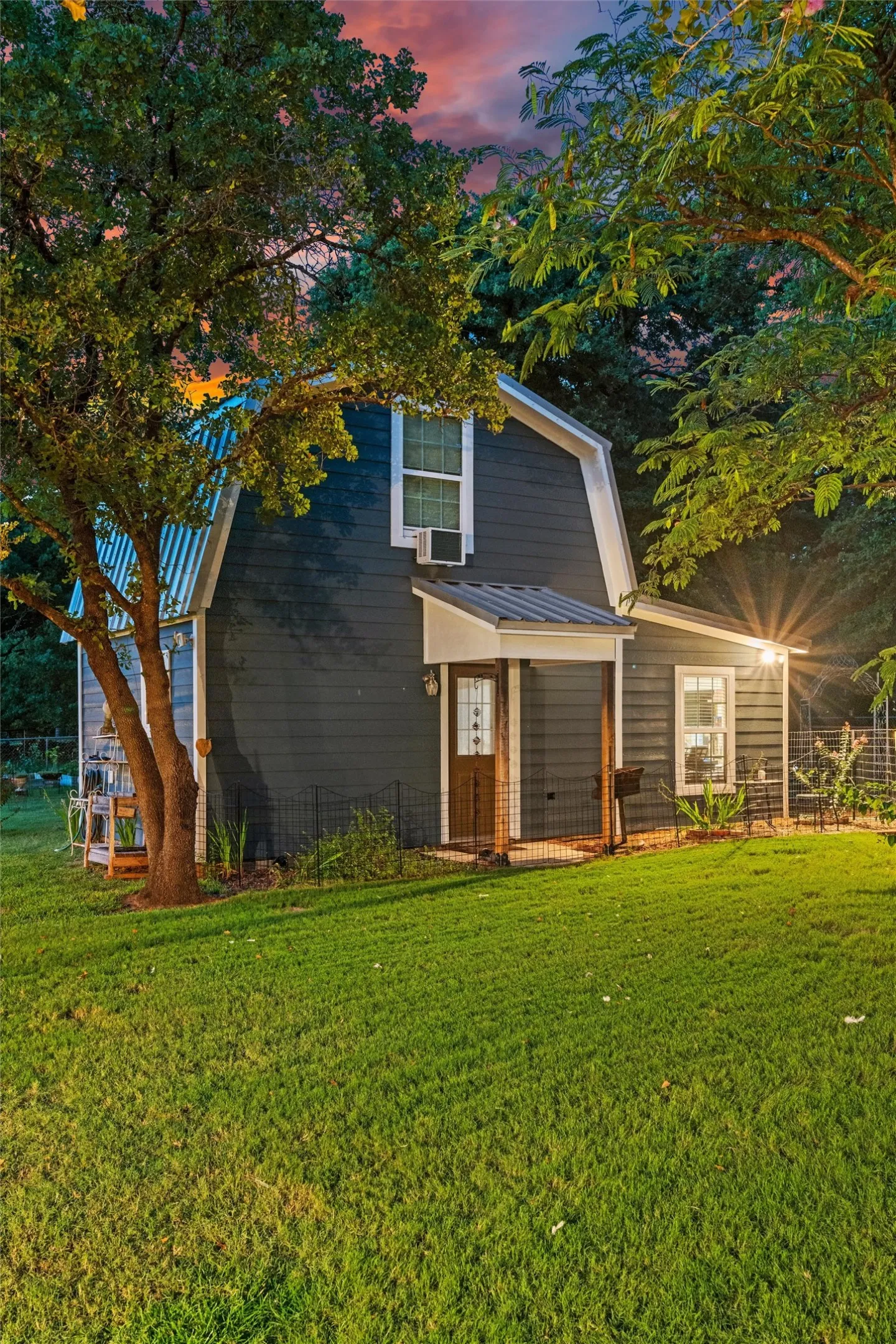 ADU exterior featuring a gambrel roof and a metal-roofed entryway