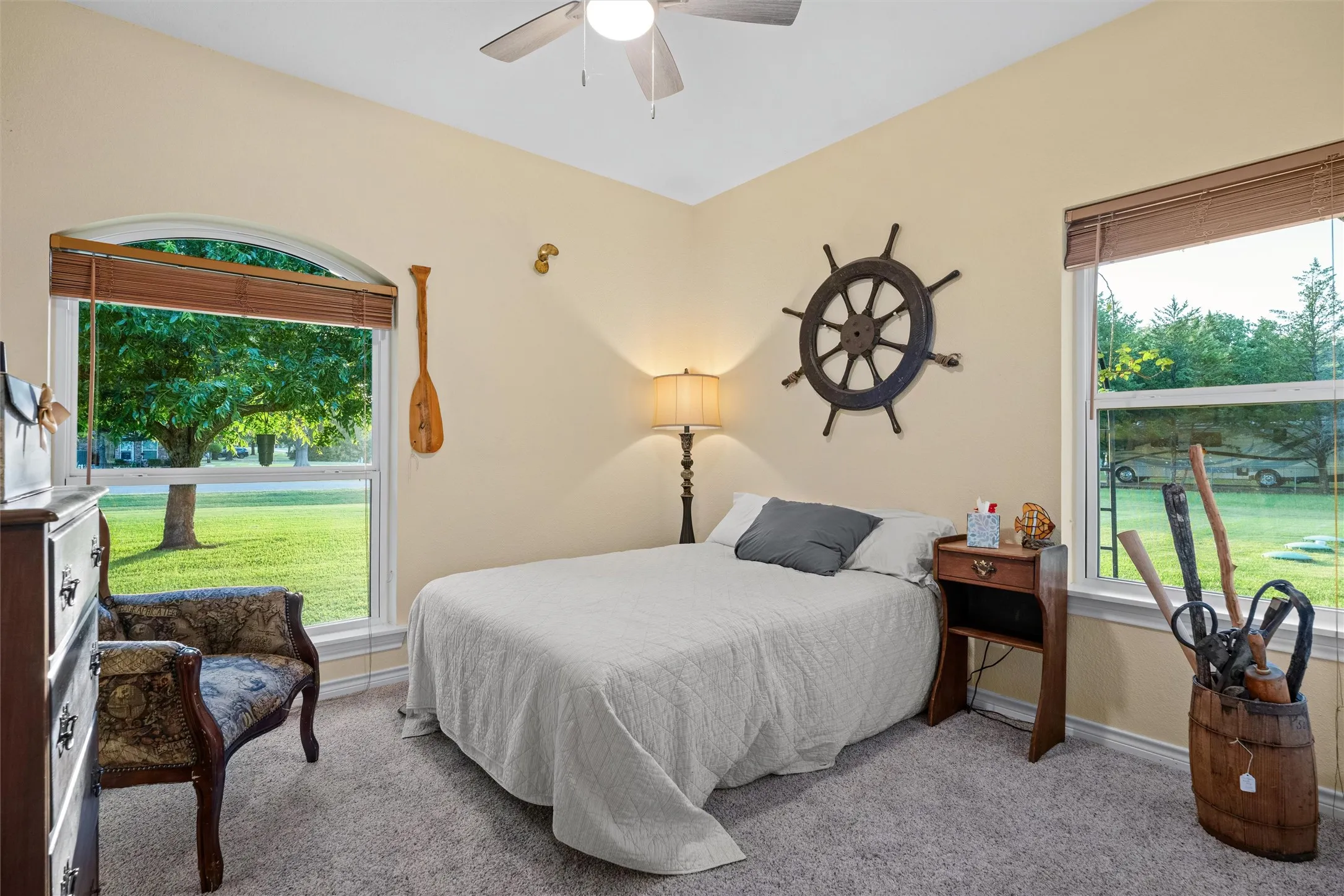 Bedroom featuring two windows, one with an arched transom, providing natural light
