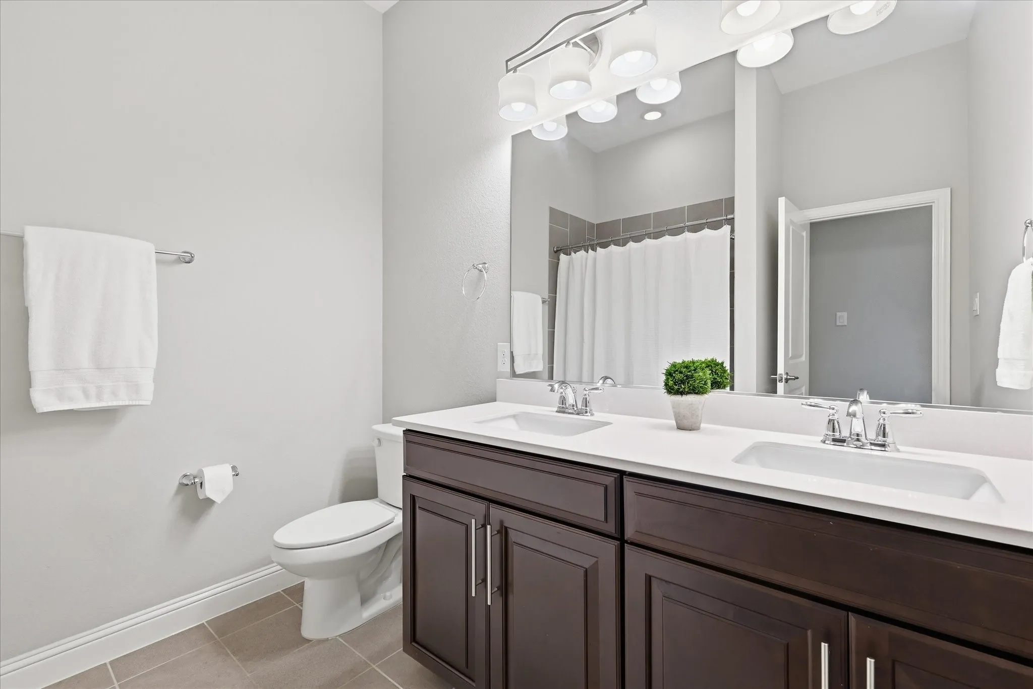 Dual vanity with white countertops and dark wood-finish cabinetry
