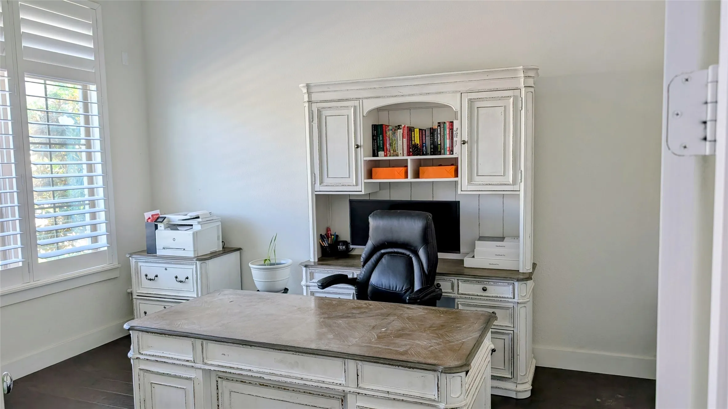 Well-lit room with dark wood-finish flooring