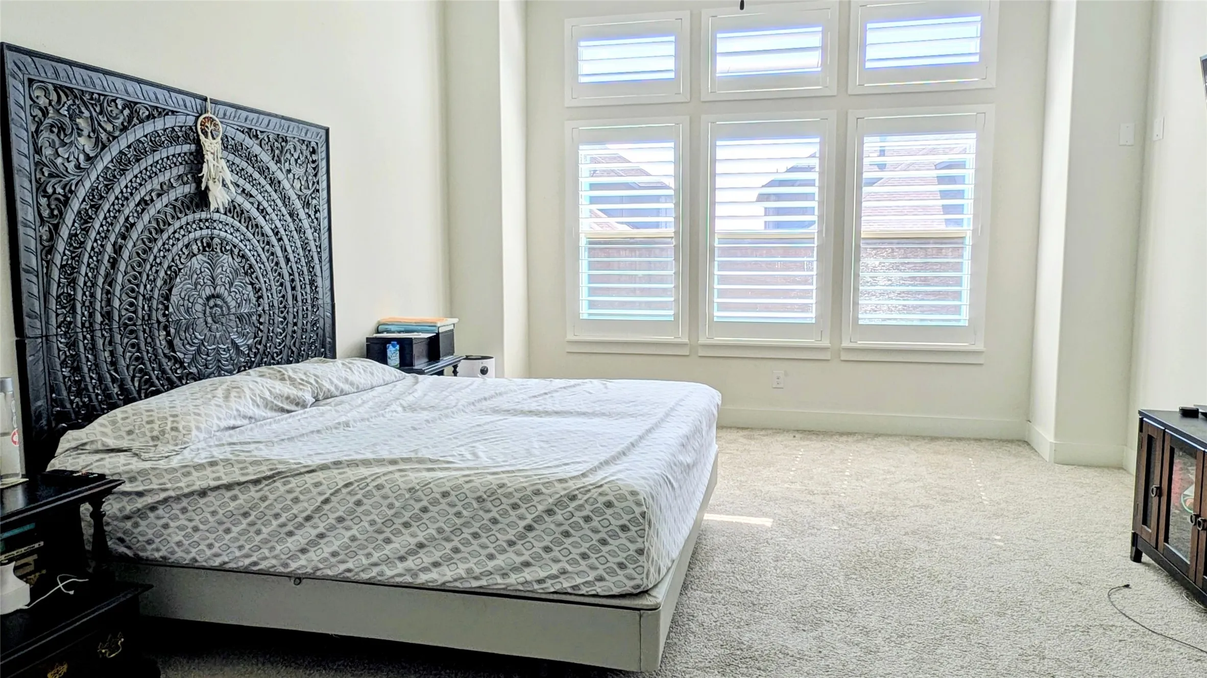 Spacious room featuring light-colored carpeting and high ceilings