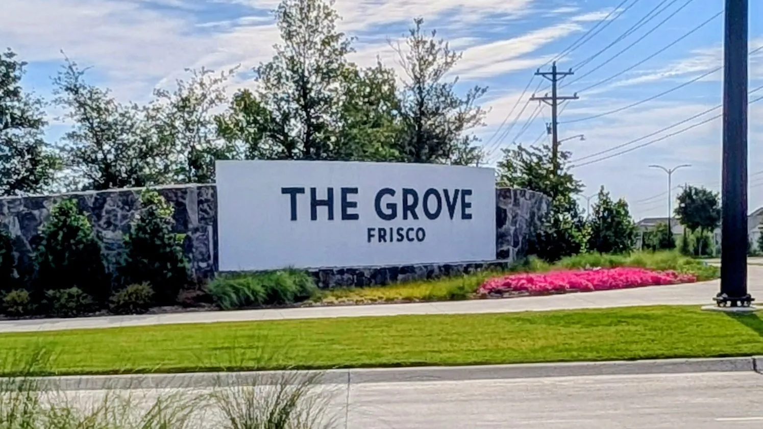 Community entrance signage featuring a stone base and white panel