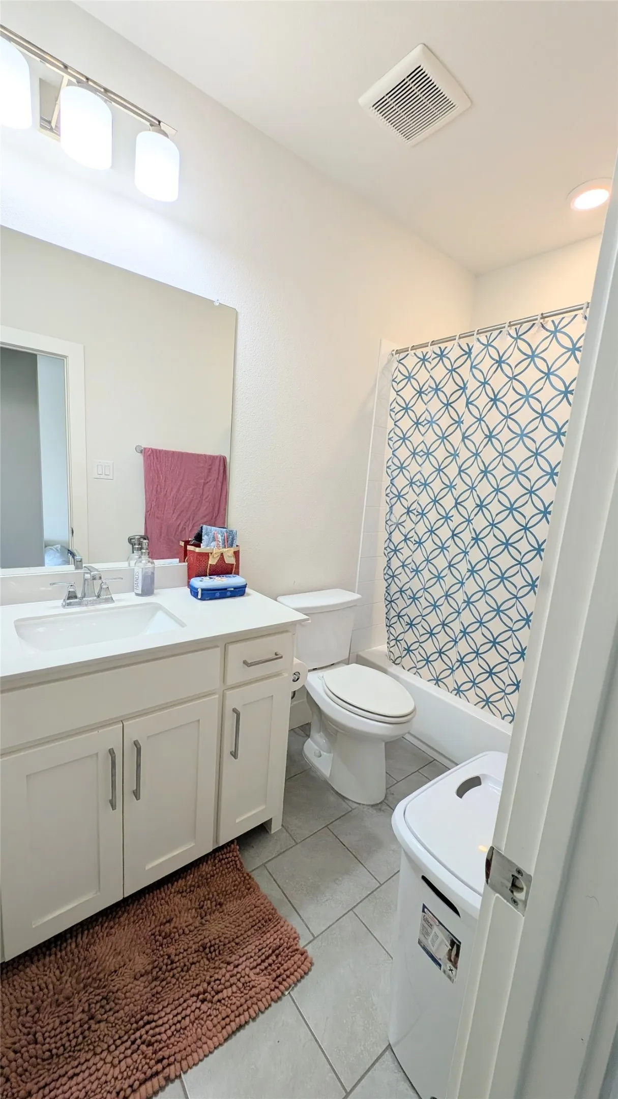 Bathroom featuring a single vanity with white cabinetry, a rectangular sink, and a chrome faucet