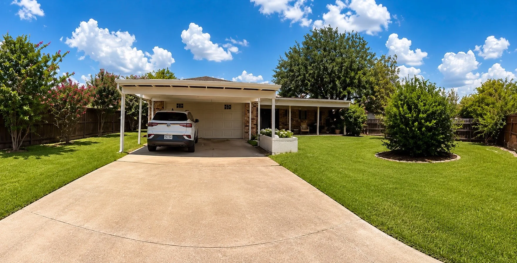 Carport with a concrete driveway and an attached garage