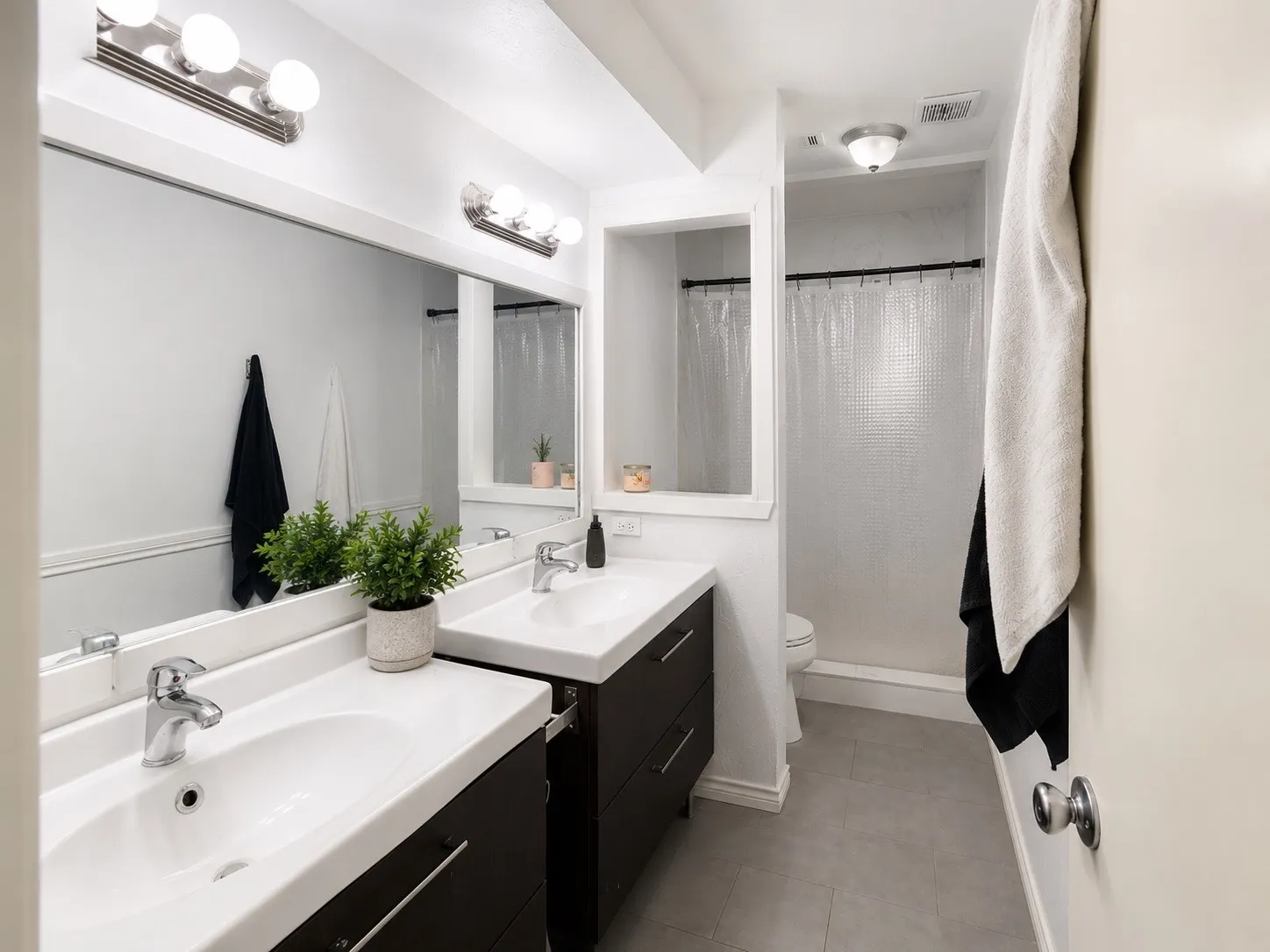 Bathroom featuring a double vanity with dark wood-finish cabinetry and chrome hardware