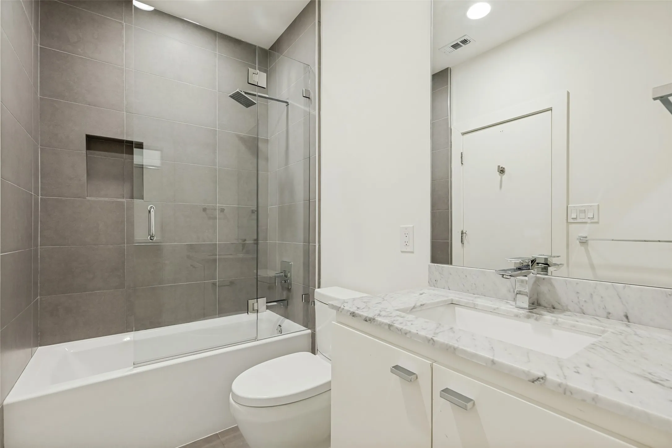 Bathroom featuring a white vanity with a stone countertop, an undermount sink, and a chrome faucet