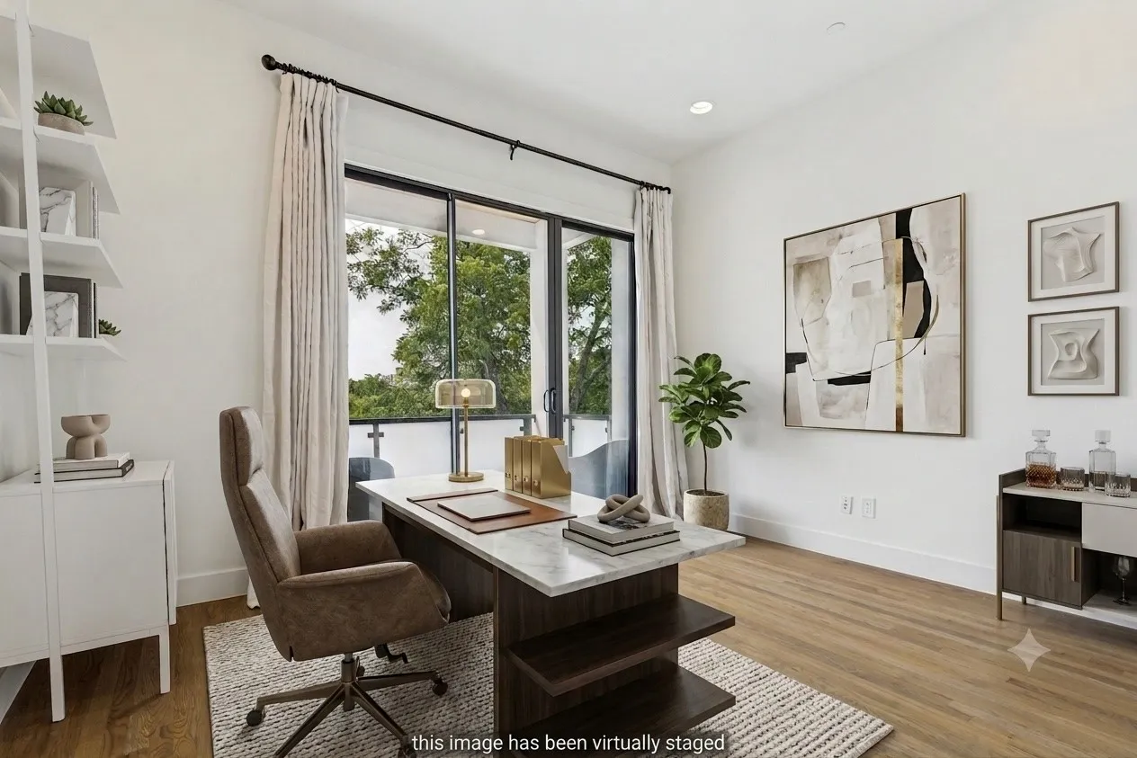 Expansive sliding glass doors open to a balcony, complemented by light wood-finish flooring, recessed lighting, and crisp white walls