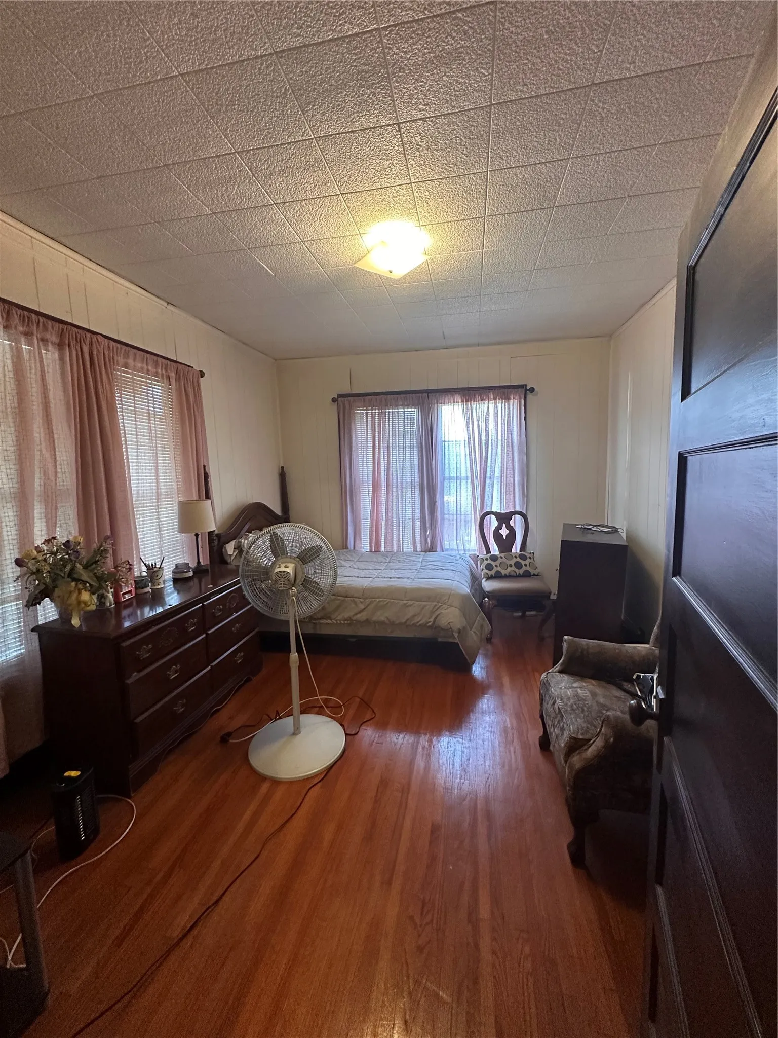 Spacious room featuring wood-finish flooring and a central ceiling light fixture