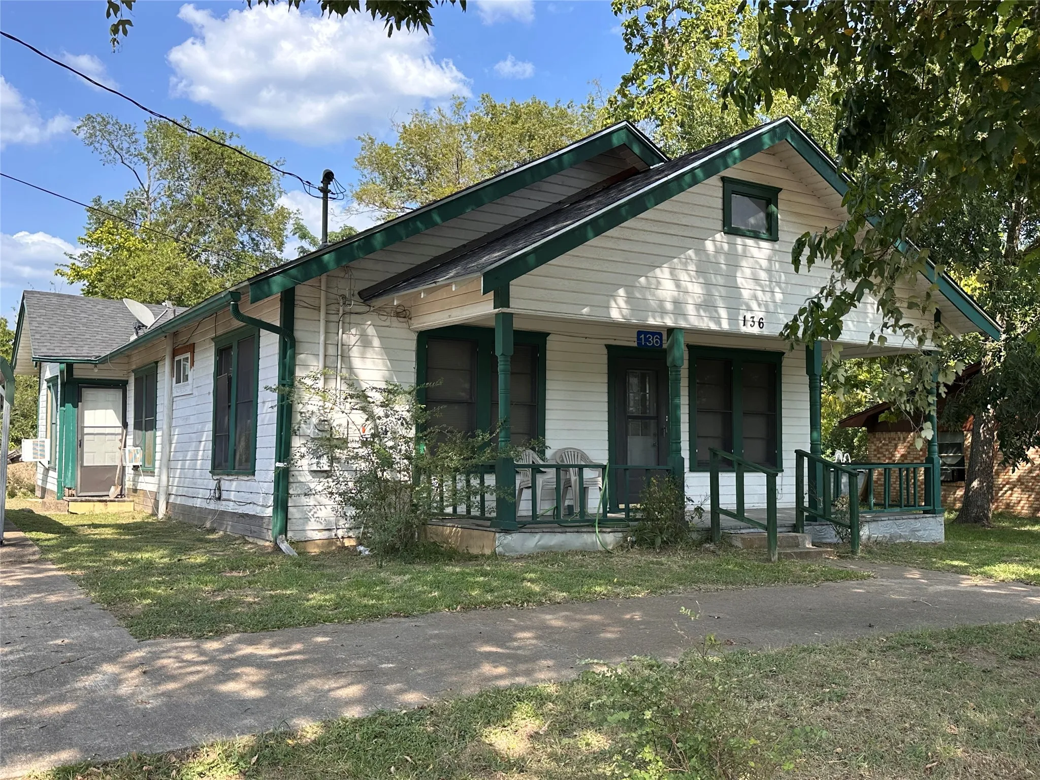 White siding exterior with dark green trim