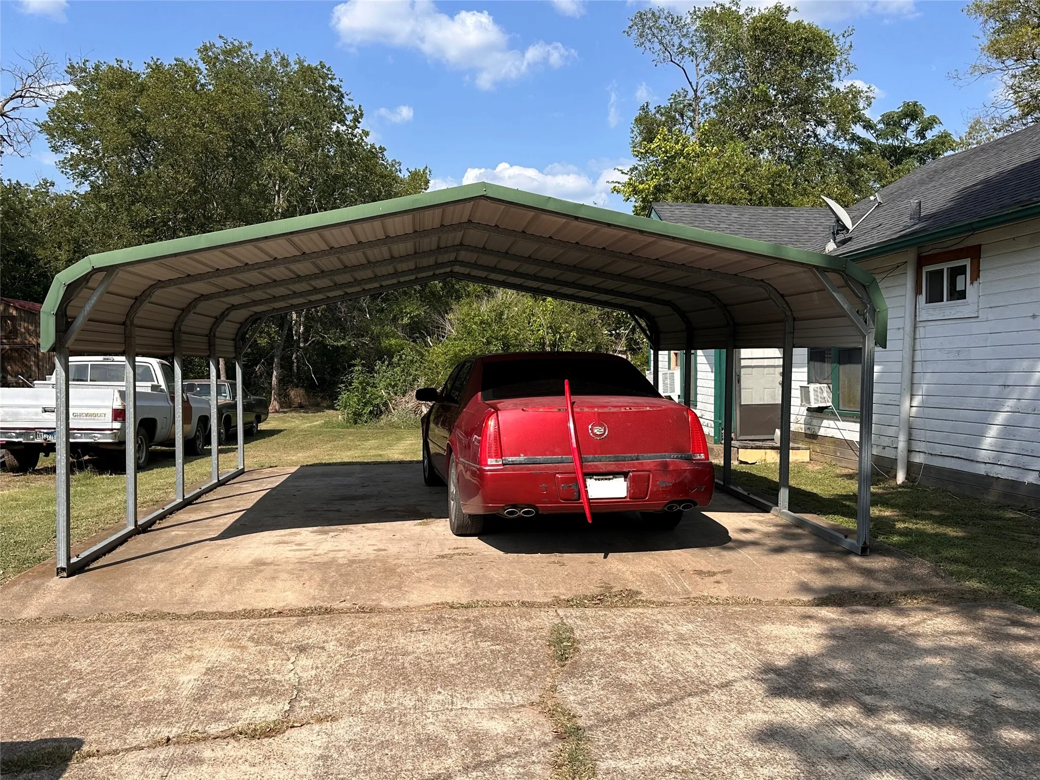 Metal carport structure with a green roof, providing covered parking