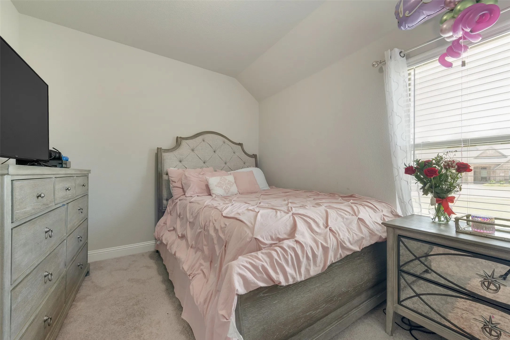 Bedroom with vaulted ceiling and light carpet