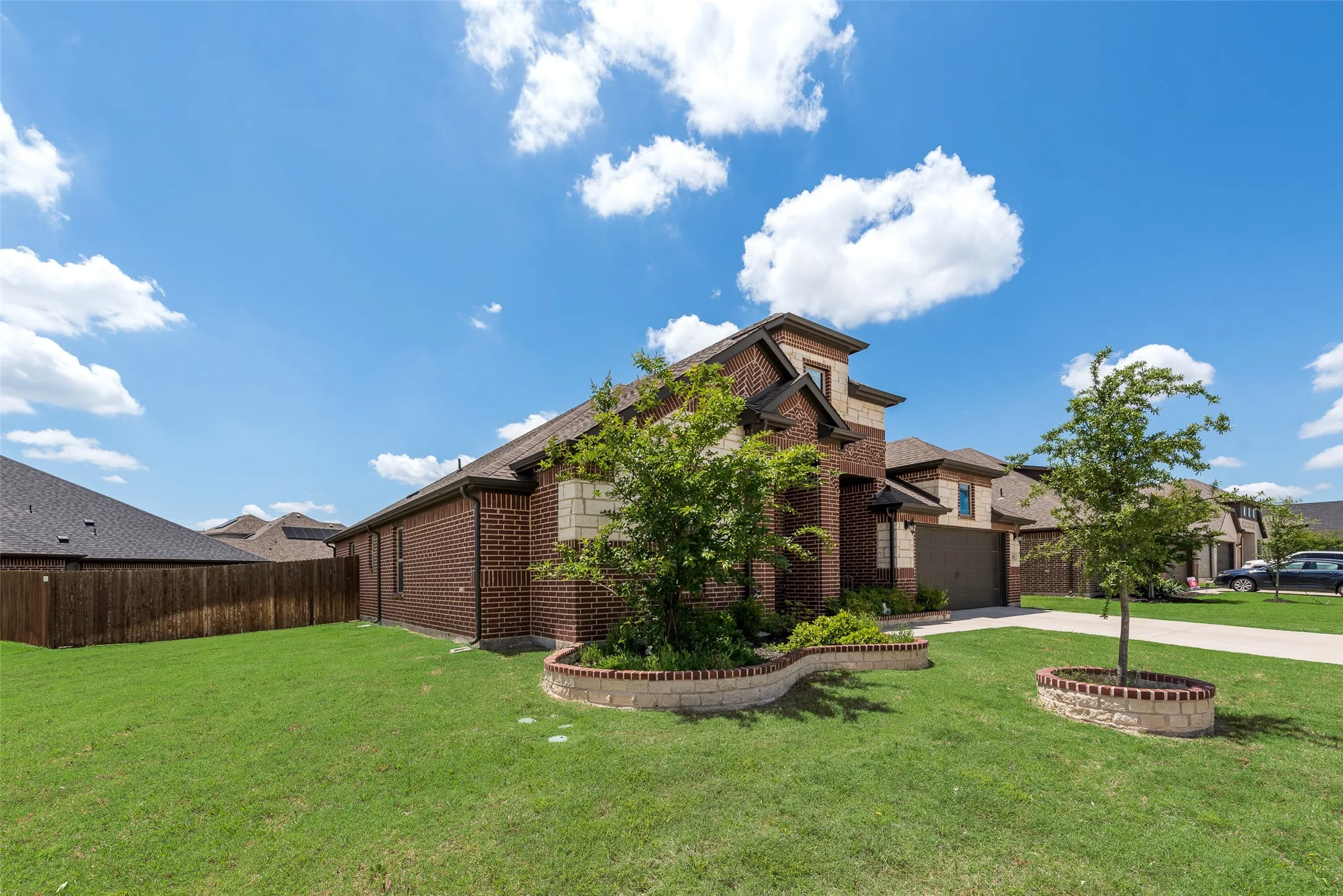 View of side of home featuring brick siding, driveway, and a garage