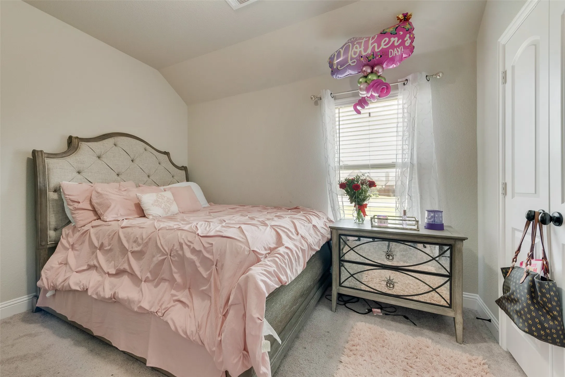 Carpeted bedroom featuring lofted ceiling and baseboards