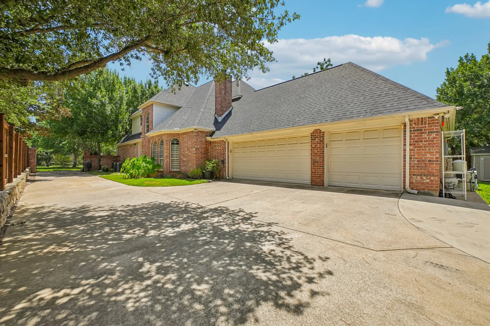 Large three car garage with gated entrance, work area and shelving