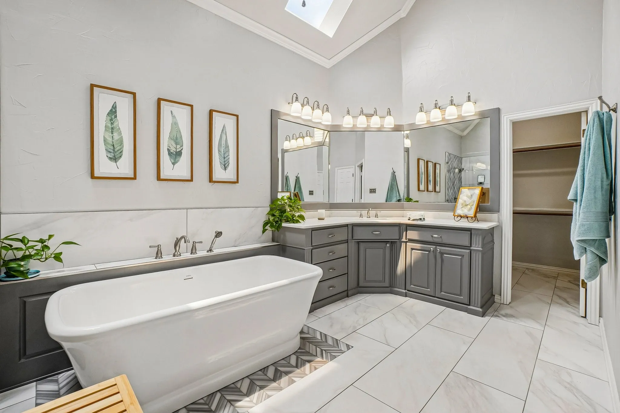 Freestanding soaking tub with brushed nickel fixtures and herringbone tile accent