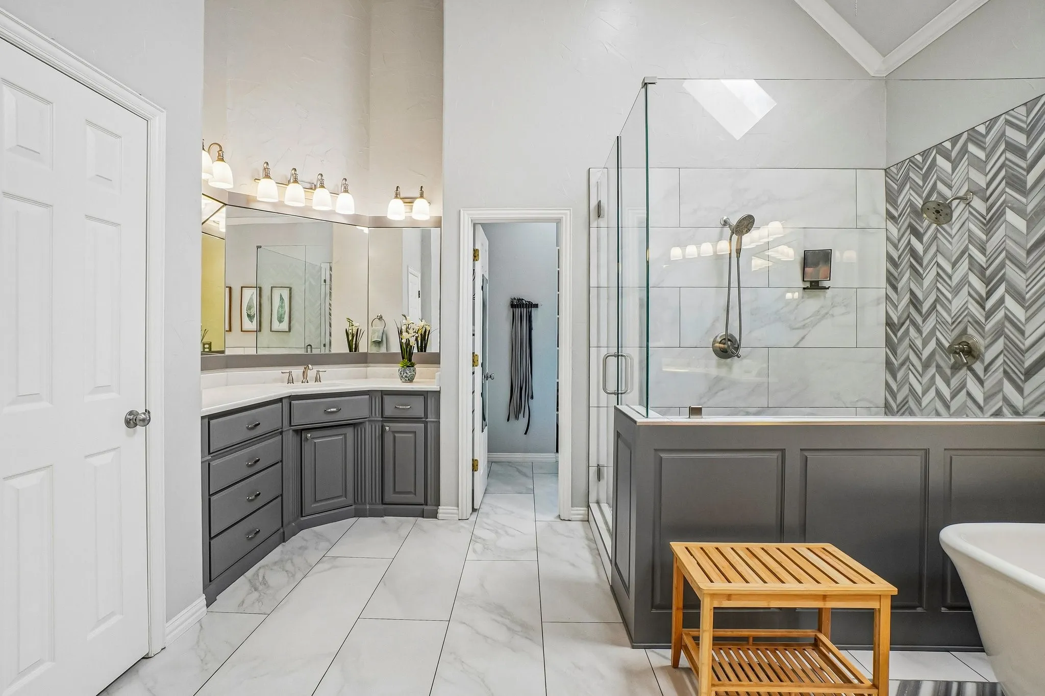 Bathroom featuring a grey corner vanity with a light-toned countertop, a glass-enclosed sh