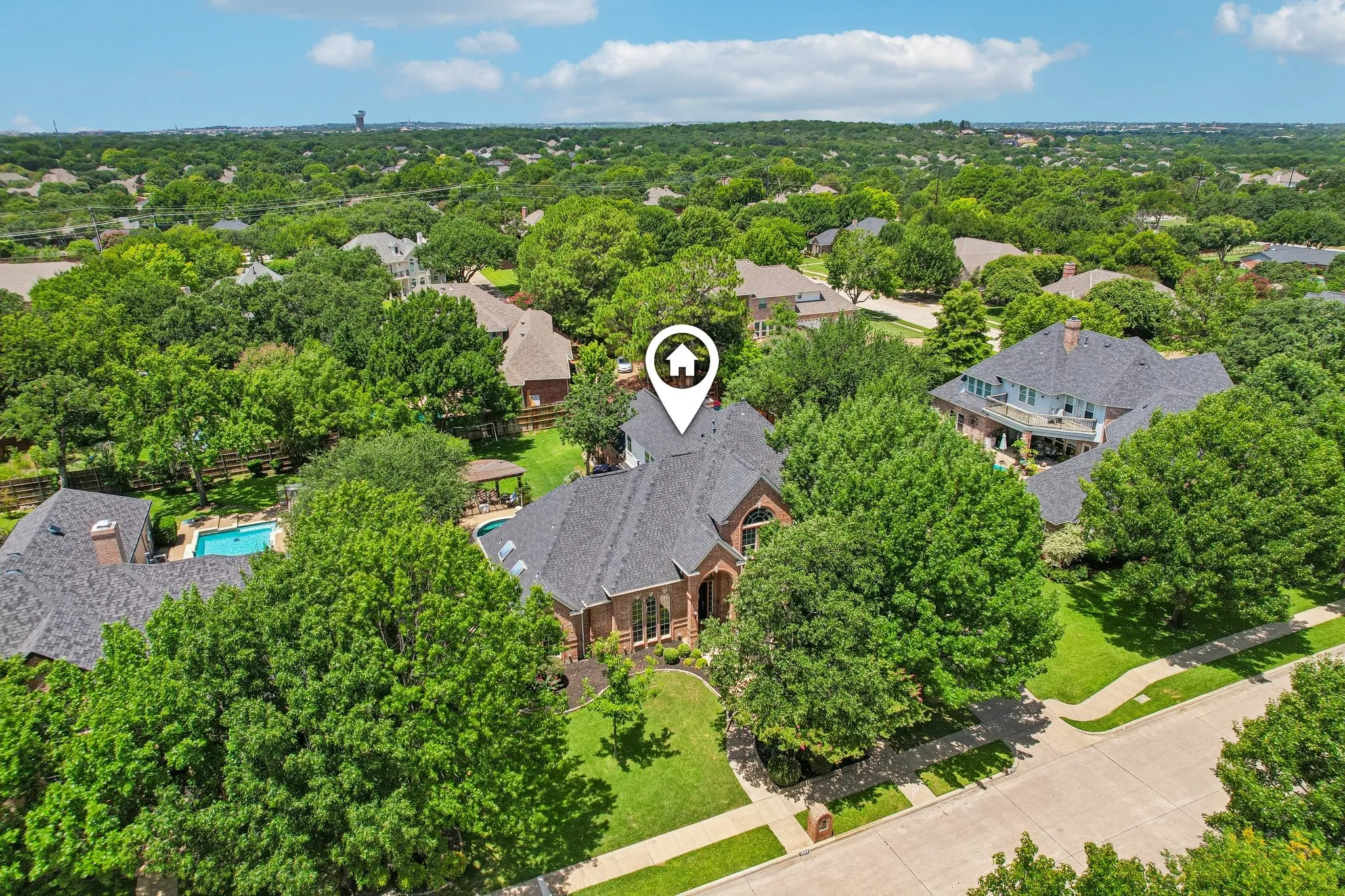 Brick residence with dark shingle roof and arched windows