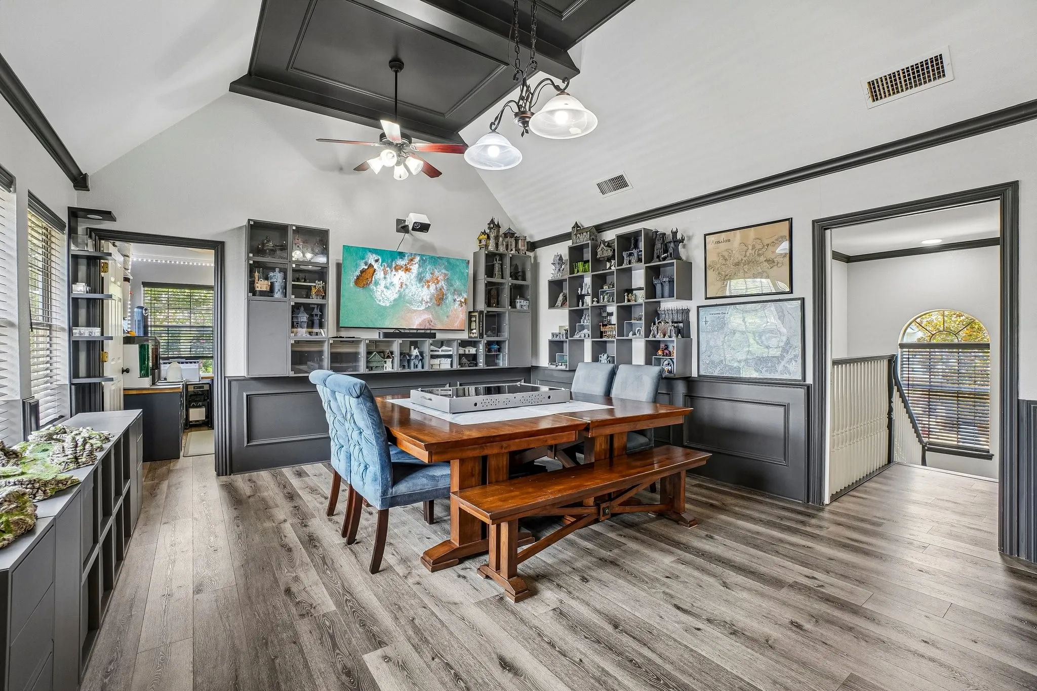 Spacious room featuring vaulted ceilings with a black coffered detail, and built-in shelving units with access to the flex room