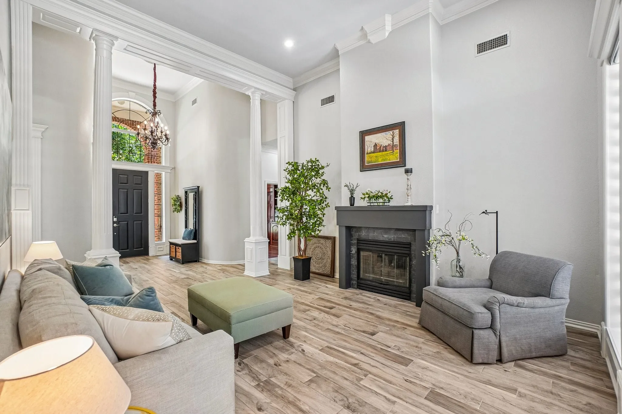 Grand entry featuring double-height ceilings, decorative columns, and wood-look tile flooring