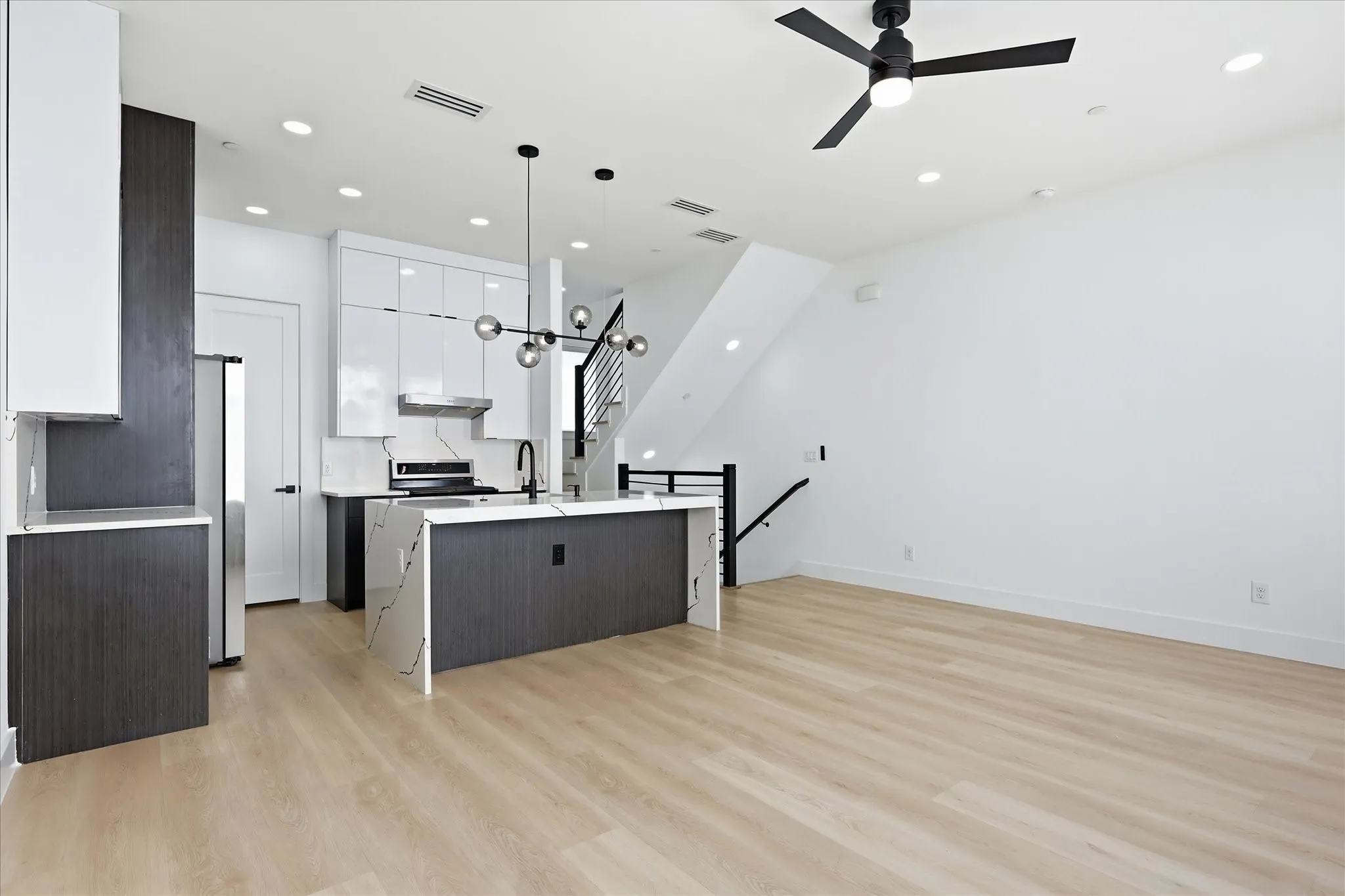 Open-concept living area with light wood-finish flooring