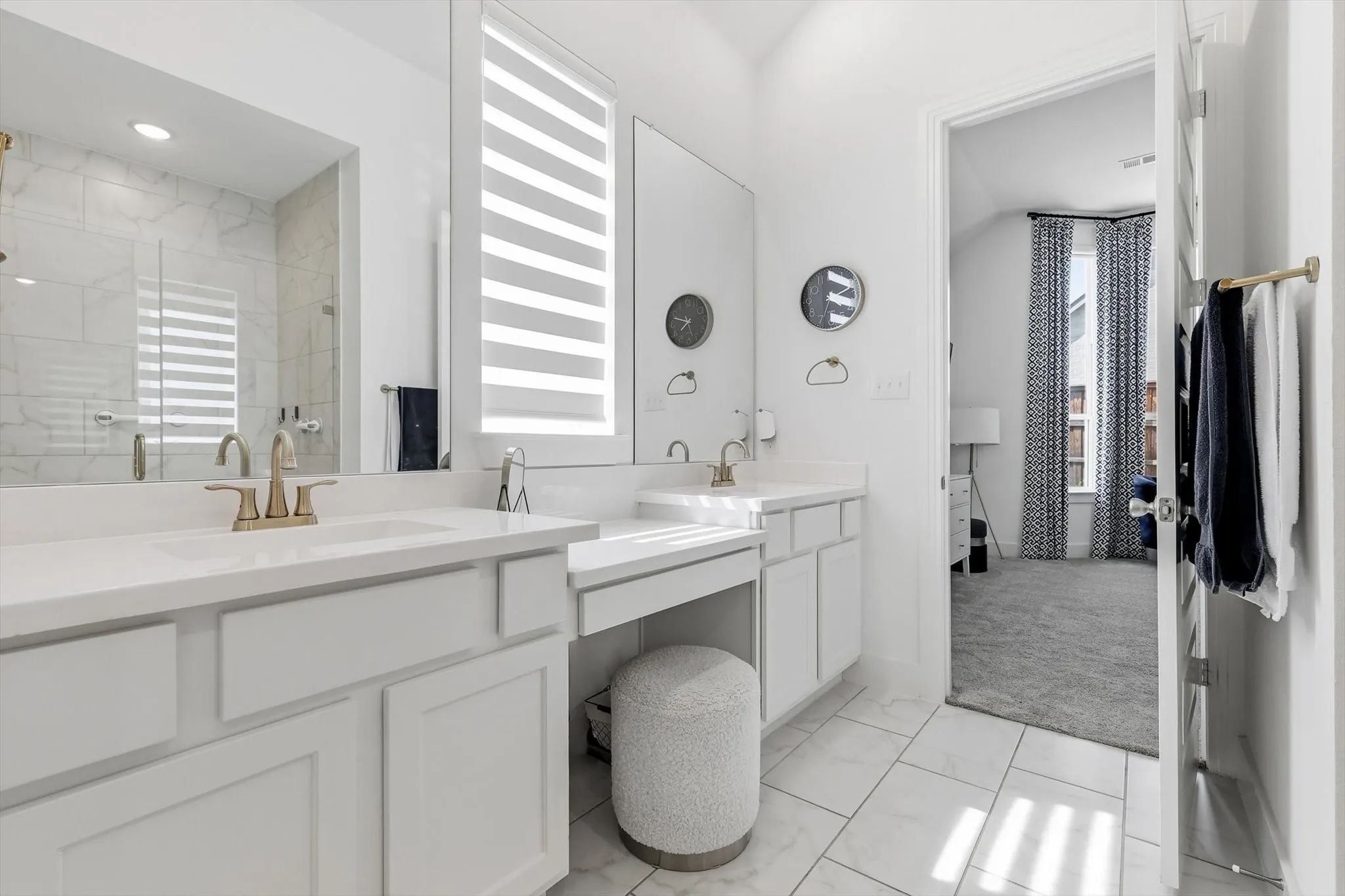 Dual vanities featuring white countertops and brass fixtures