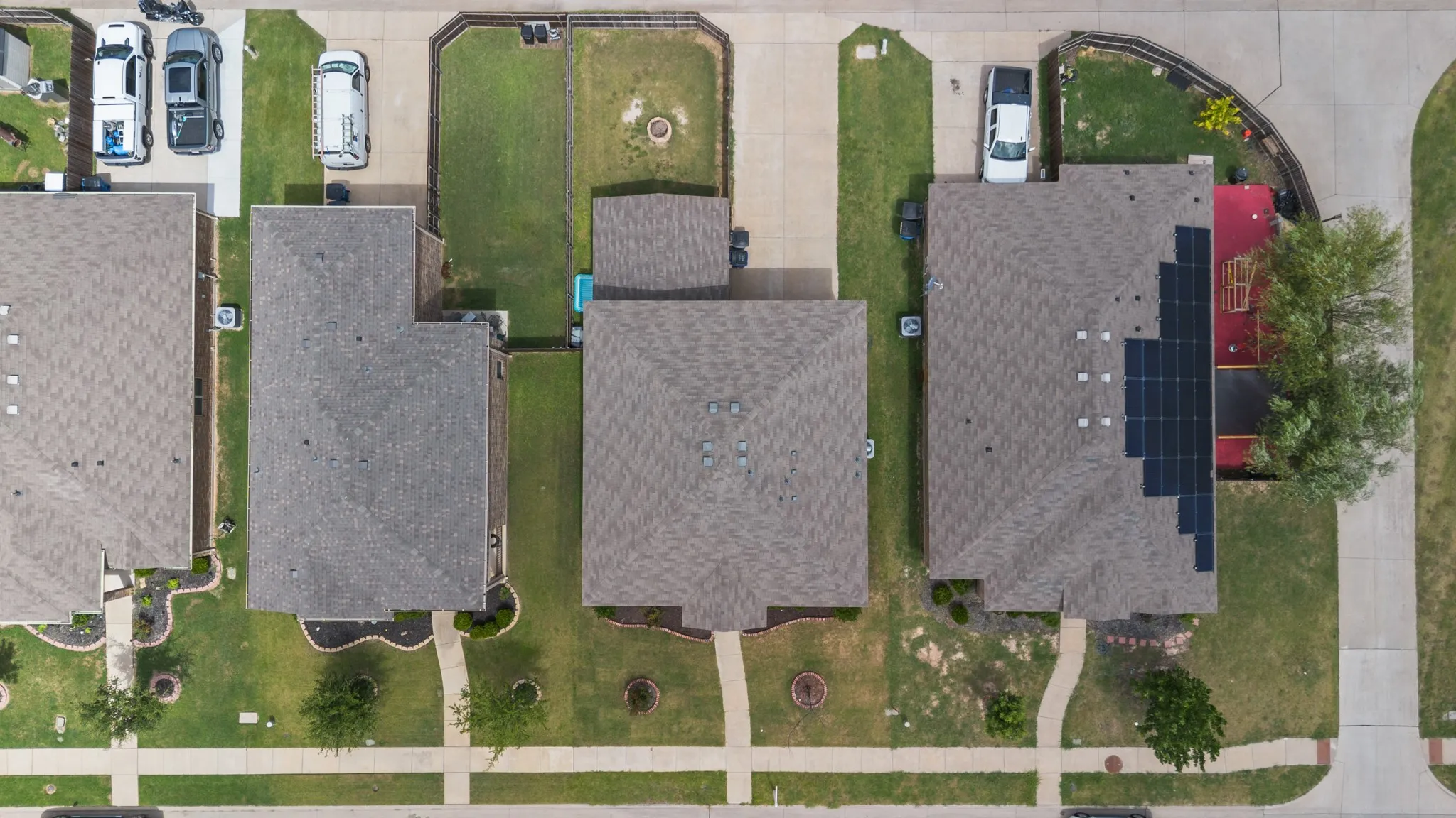 Aerial perspective showcasing a residential property with a shingle roof and a green lawn