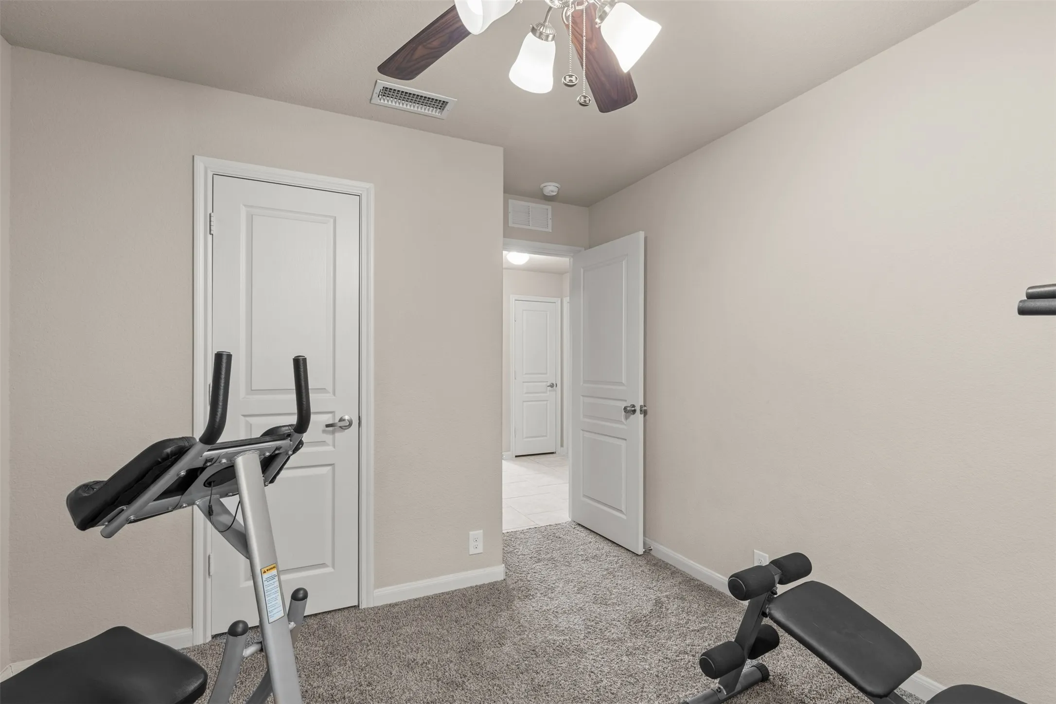 Bedroom features walk-in closet, carpet, ceiling fan