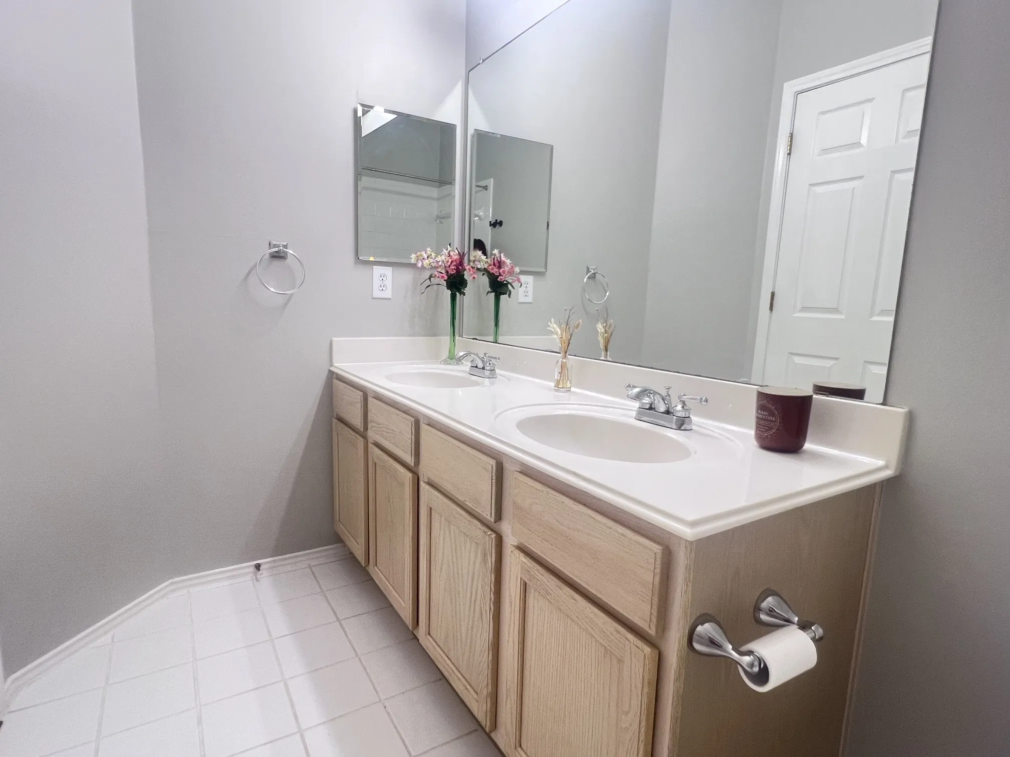 Double vanity with wood-finish cabinetry and a white countertop