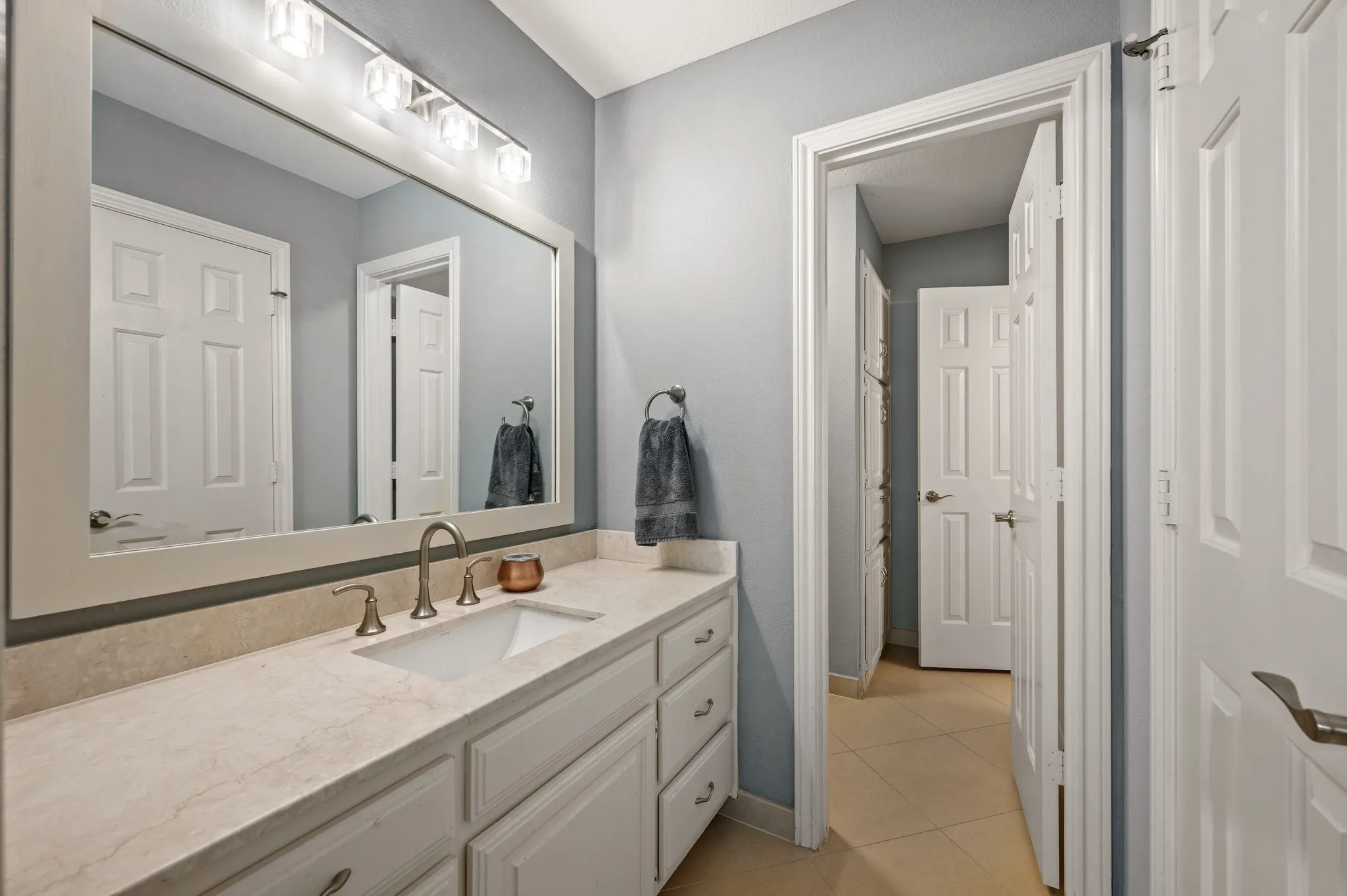 Bathroom vanity featuring an integrated sink, brushed nickel faucet, and a light-toned countertop