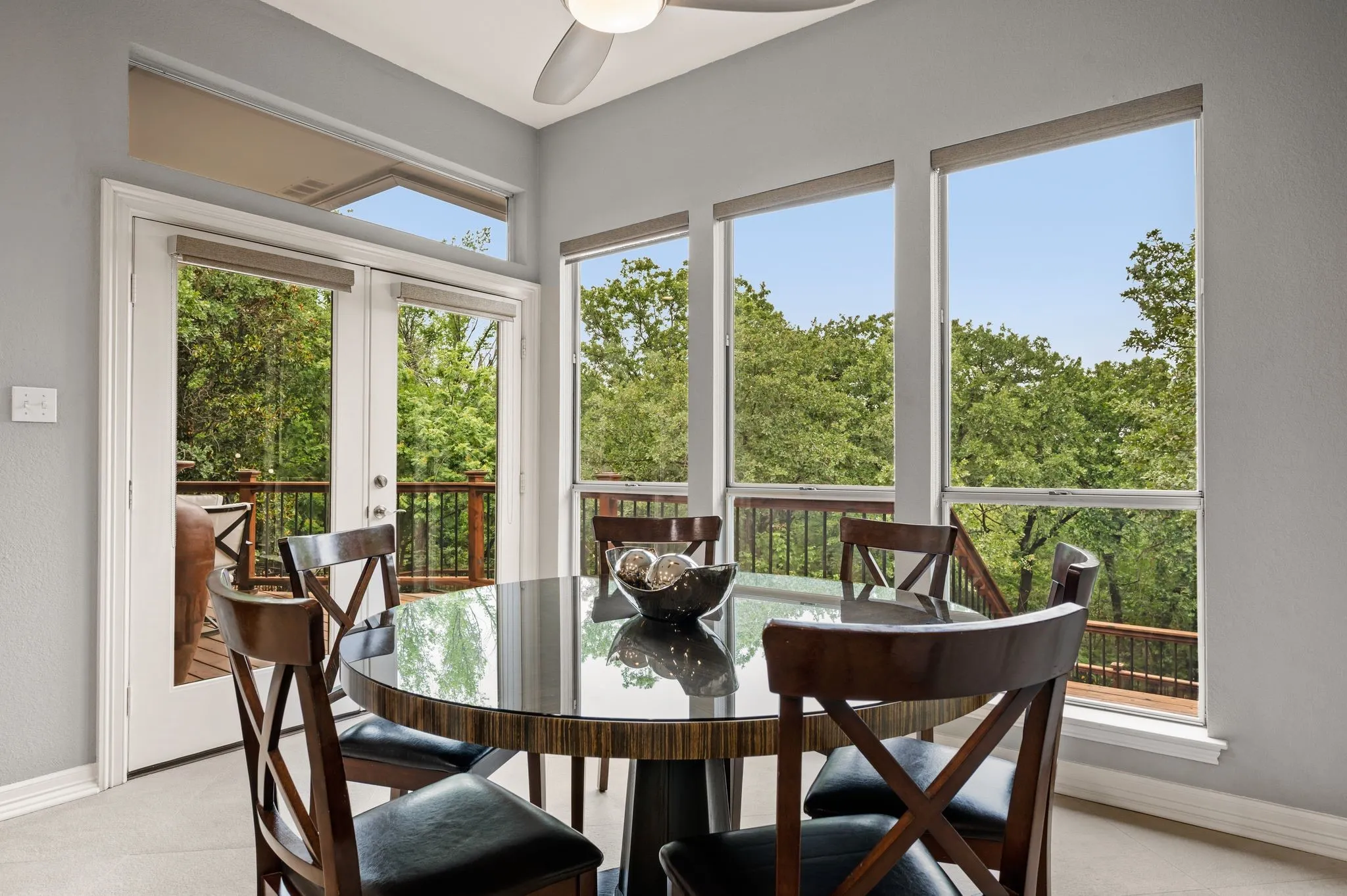 Dining area featuring multiple large windows and glass-paneled French doors leading to an exterior deck