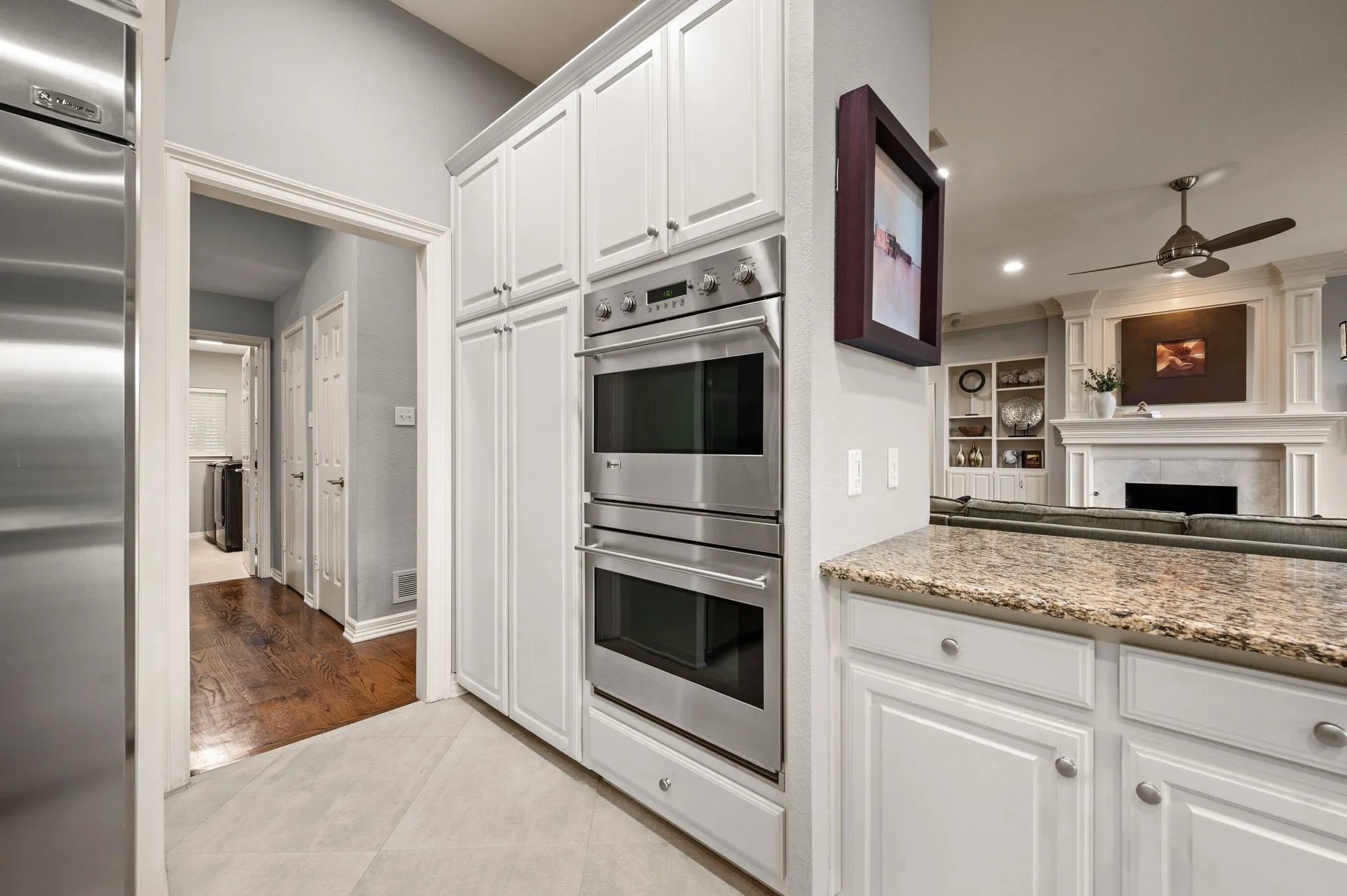 Kitchen featuring white cabinetry, stainless steel double wall ovens, a granite-style countertop, and tile​​‌​​​​‌​​‌‌​‌‌​​​‌‌​‌​‌​‌​​​‌​​ flooring