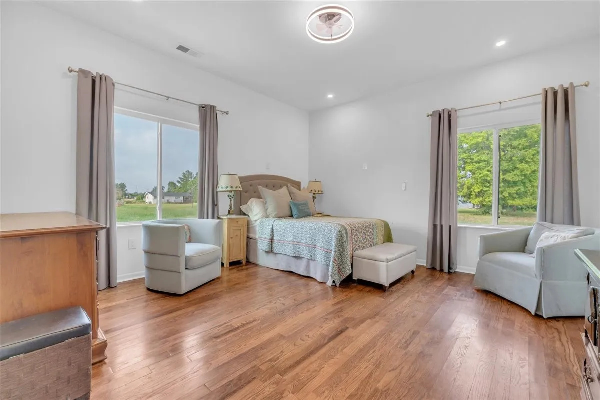 Spacious room featuring wood-finish flooring and white walls