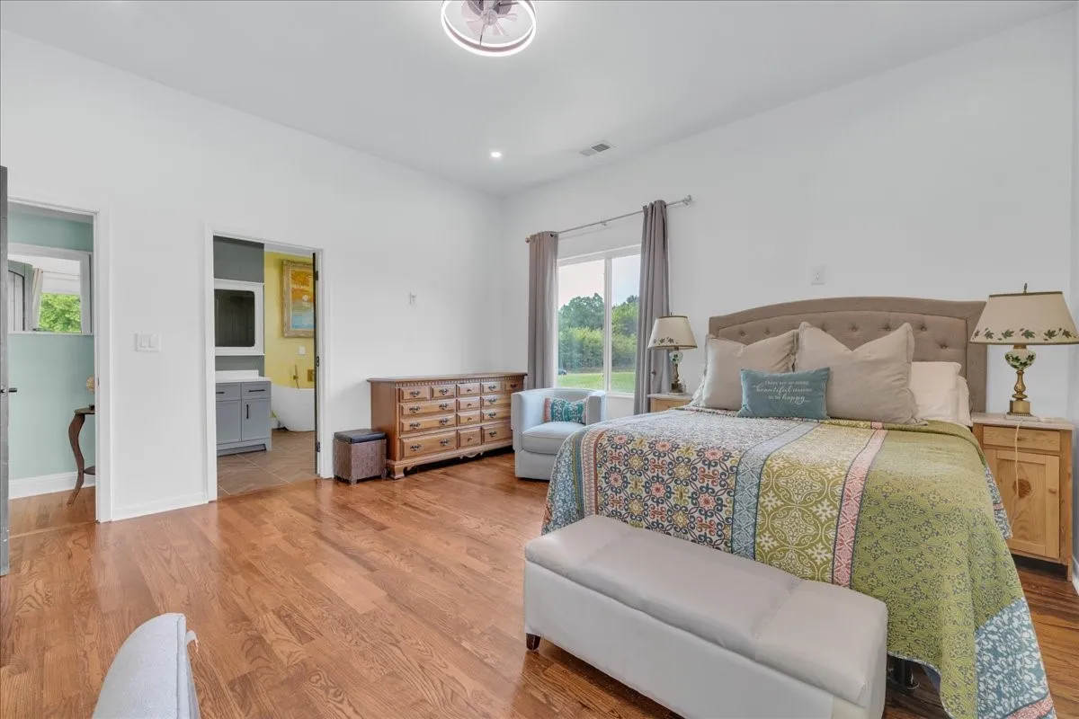 Spacious room with wood-finish flooring and white walls
