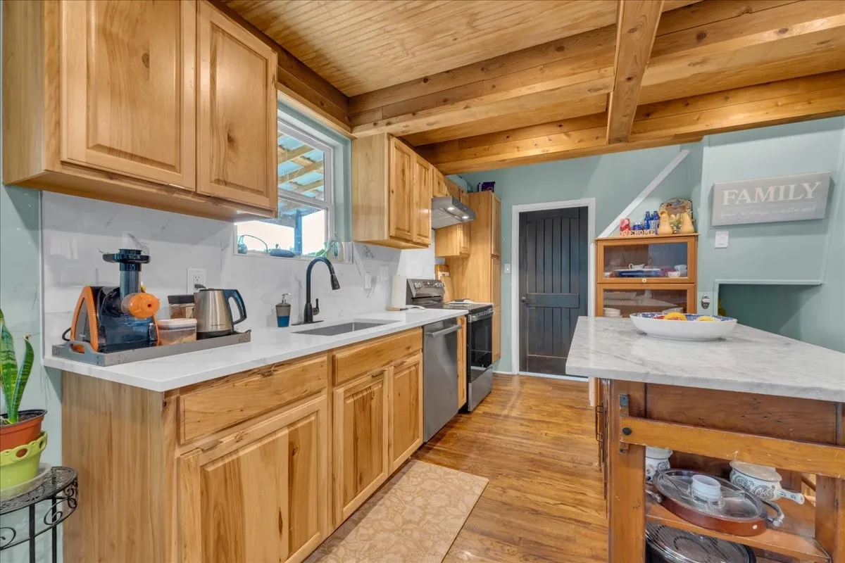 Kitchen featuring wood-finish flooring and a wood beam ceiling