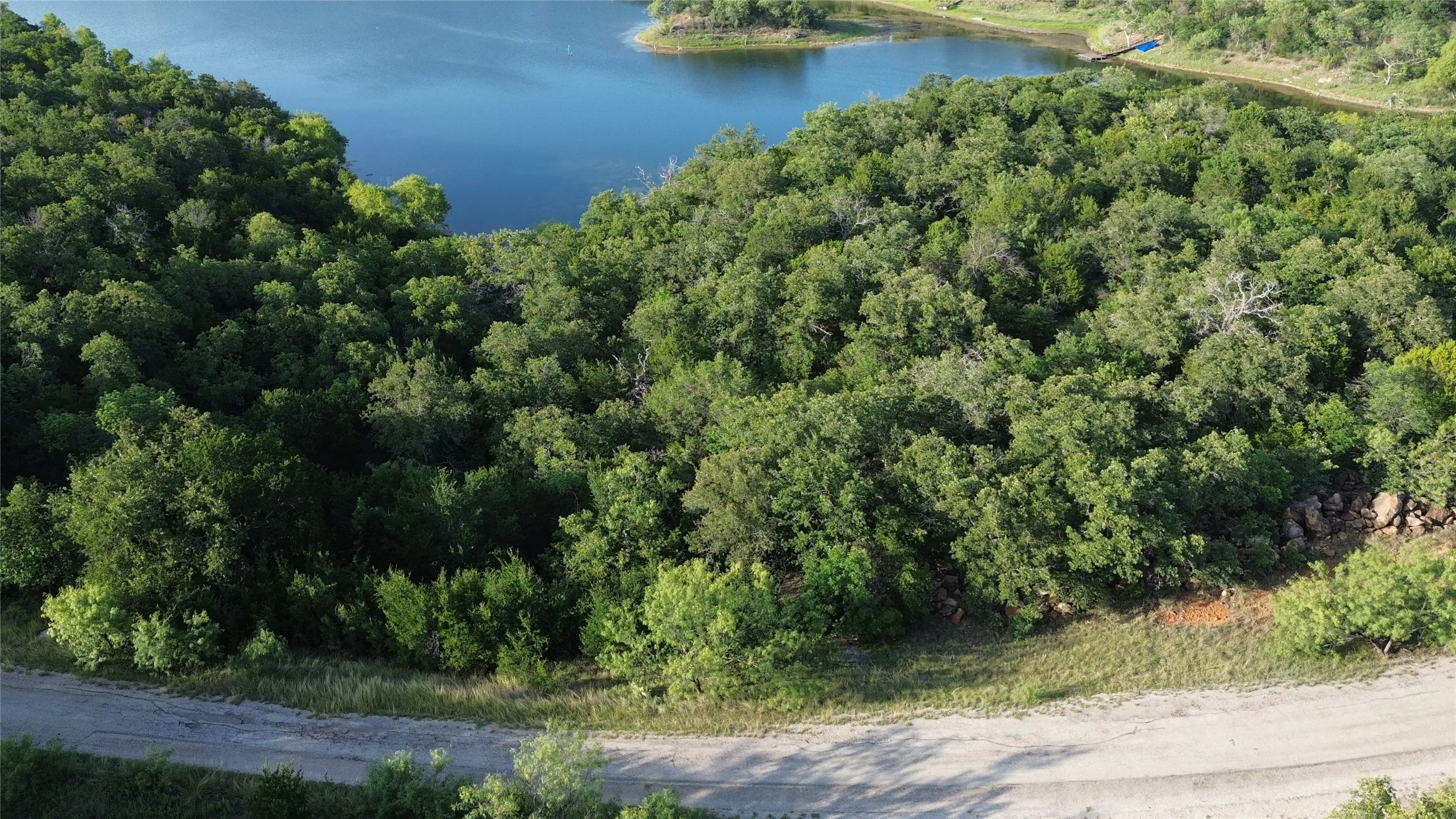 Expansive acreage featuring abundant mature trees, a natural slope, and partial water frontage