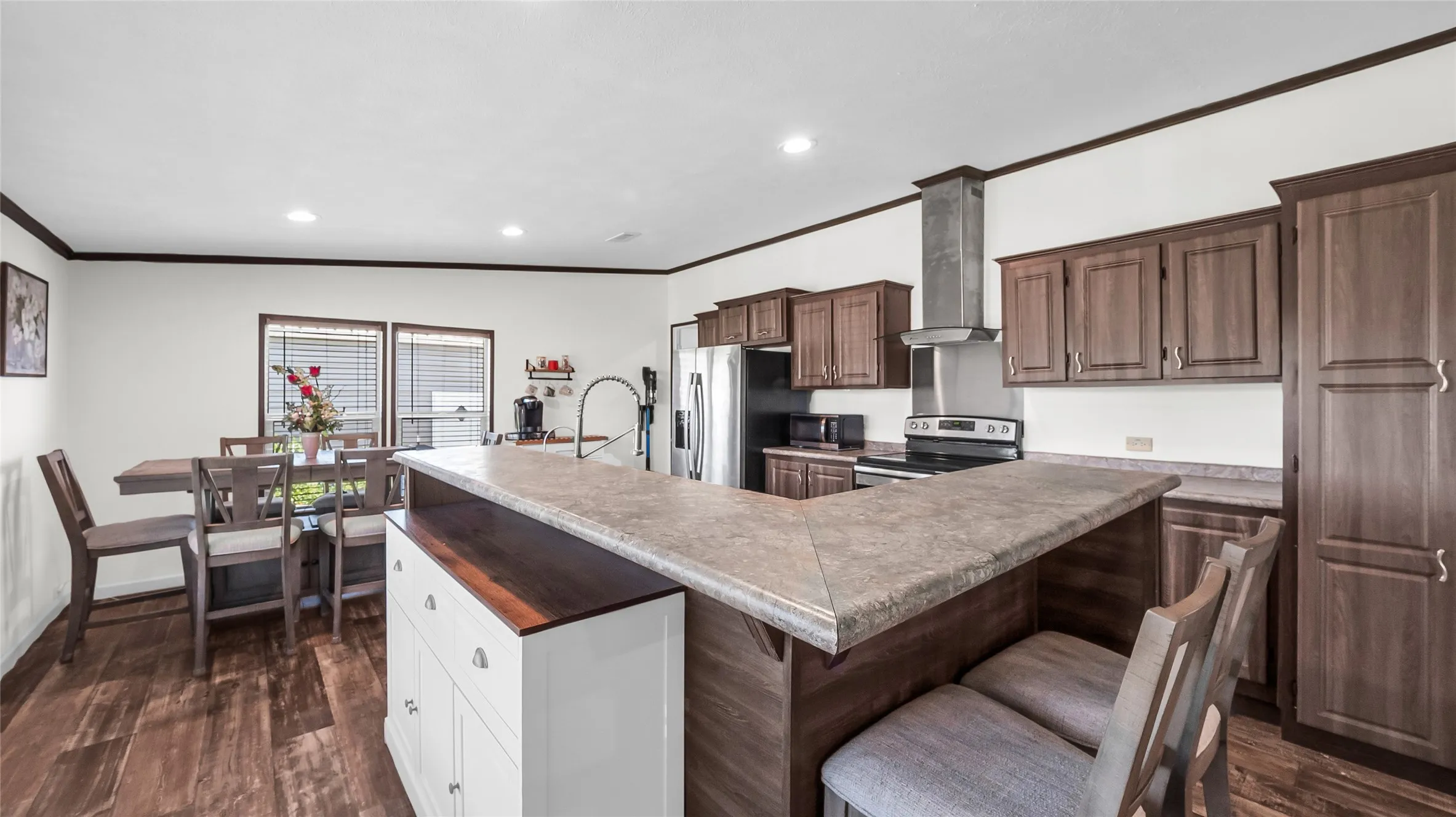 Open-concept kitchen and dining area featuring laminate flooring