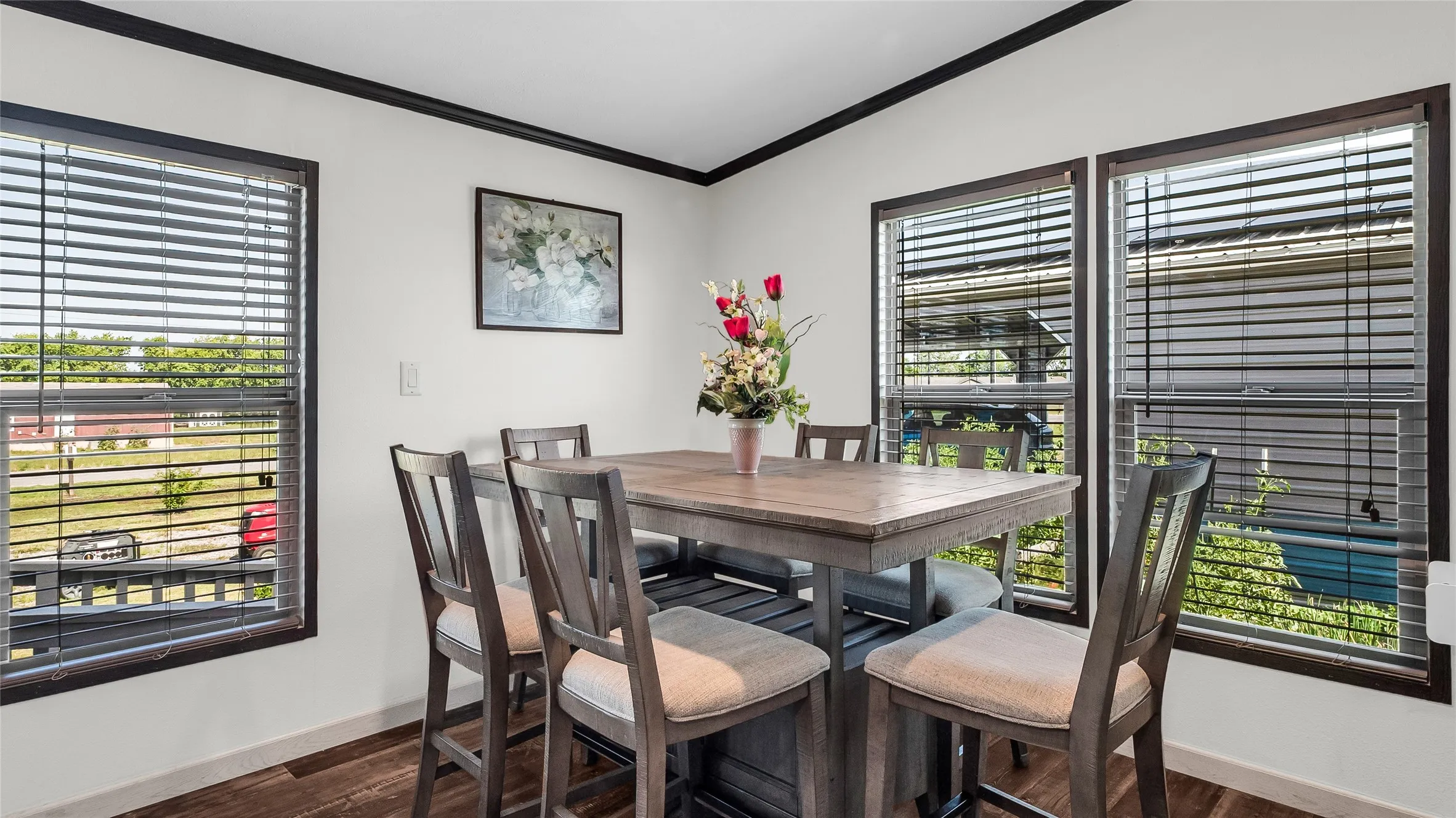 Dining area with laminate flooring, white walls, and dark trim