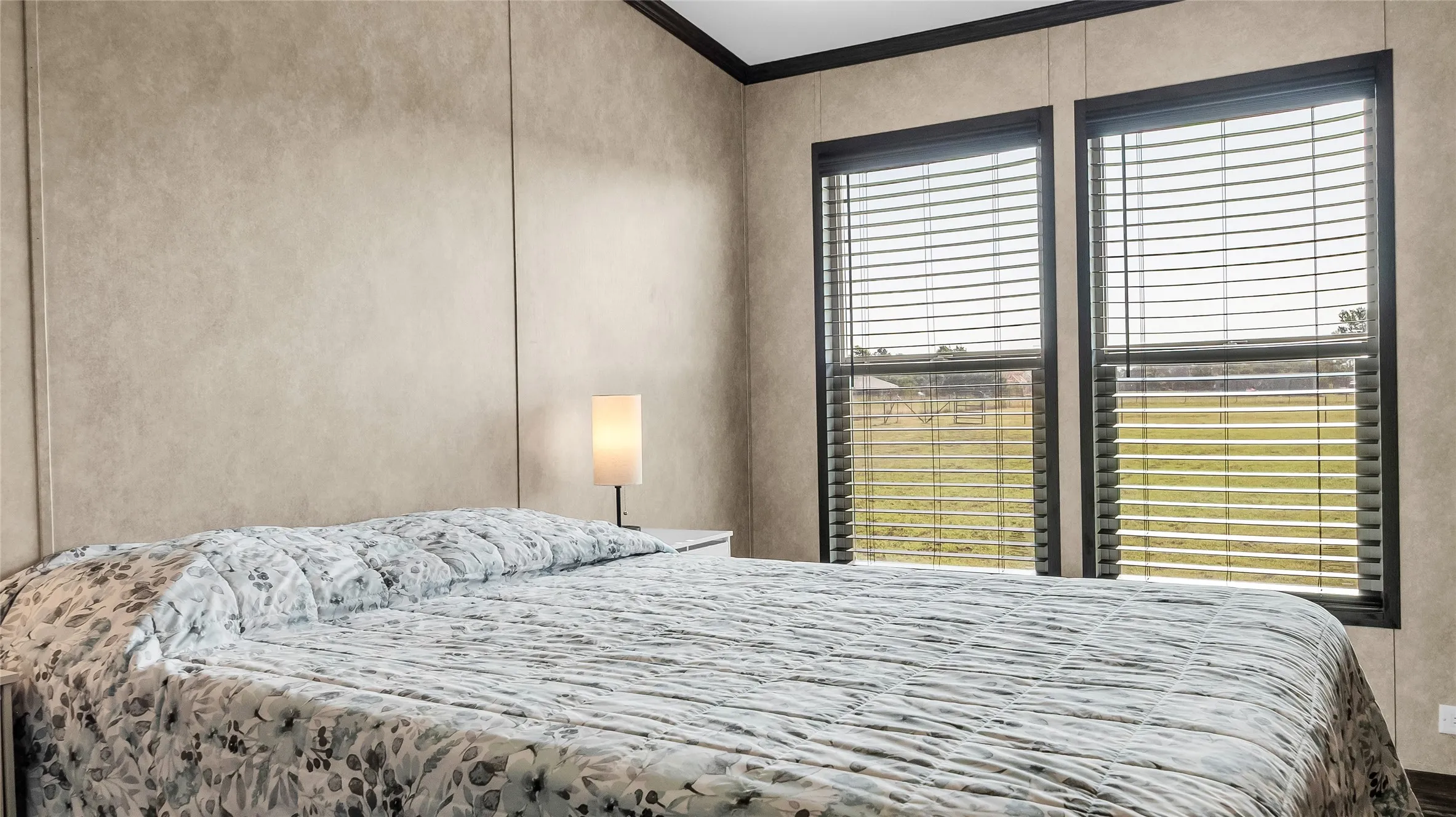 Room featuring two windows with horizontal blinds, contrasting dark trim, and light-toned wall paneling