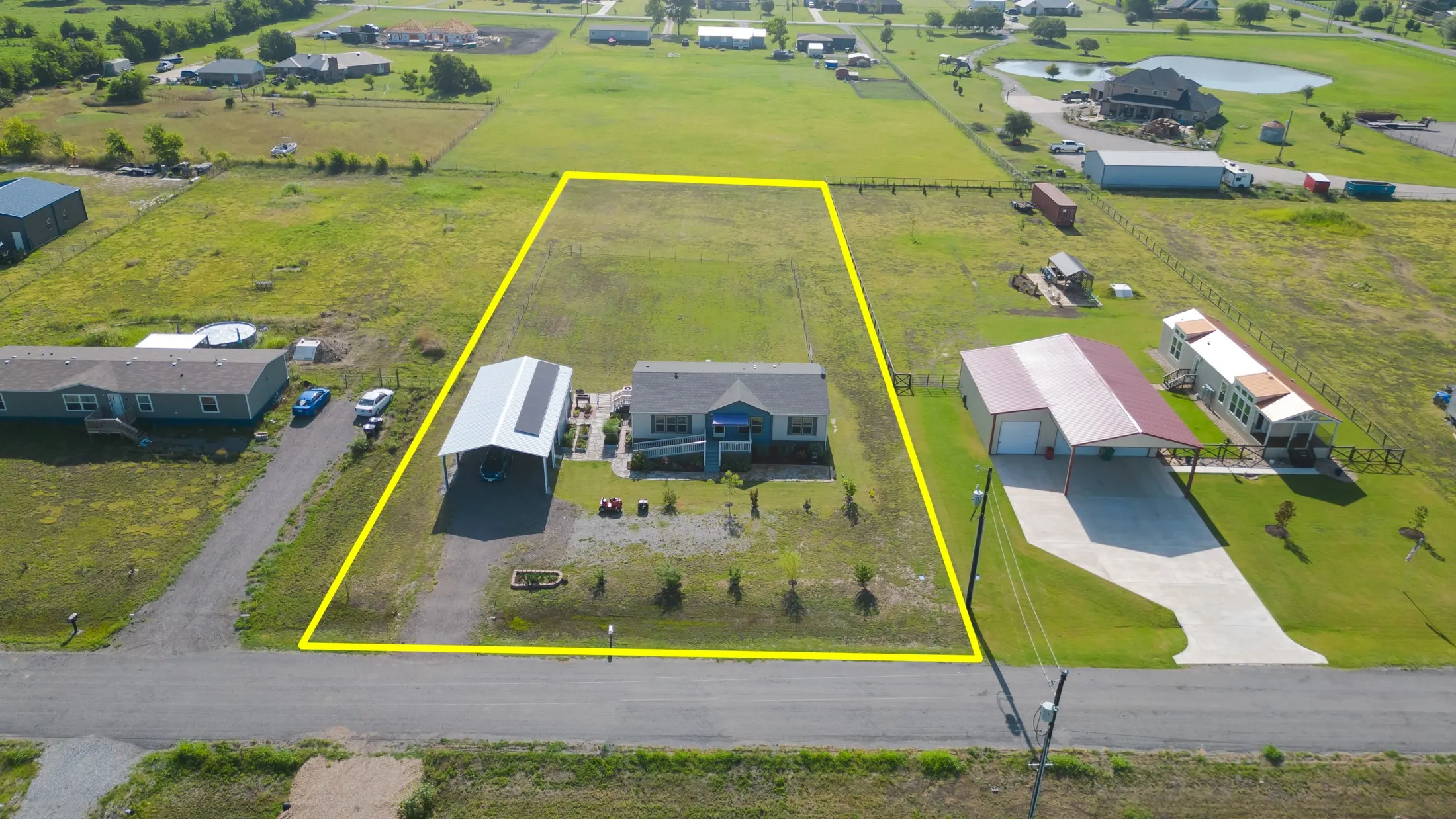 Expansive property featuring a residence, detached carport, and substantial undeveloped land